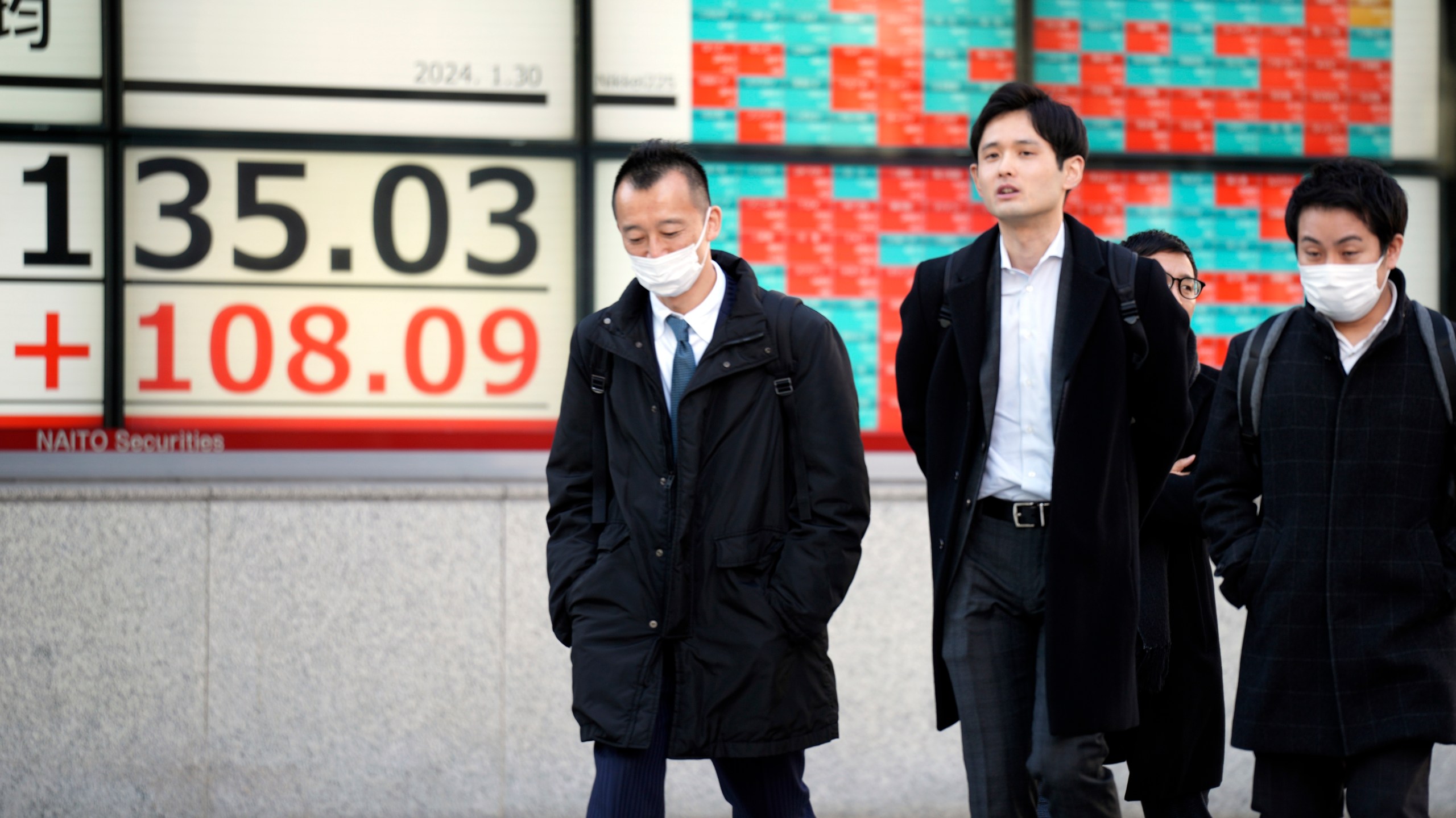 People walk in front of an electronic stock board showing Japan's Nikkei 225 index at a securities firm Tuesday, Jan. 30, 2024, in Tokyo. Asian shares were mixed on Tuesday, with Hong Kong and Shanghai leading declines, ahead of a decision by the Federal Reserve this week on interest rates. (AP Photo/Eugene Hoshiko)