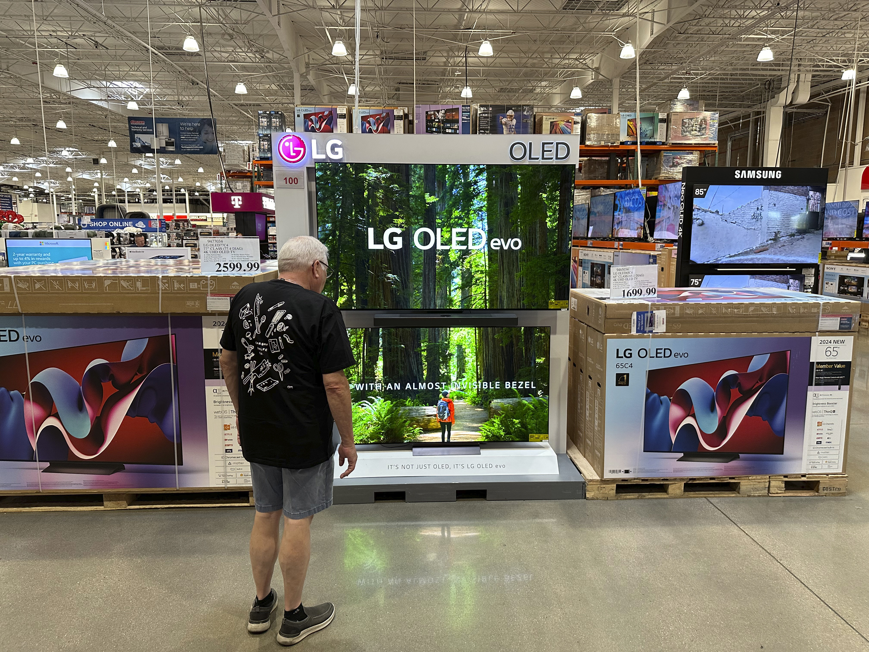 A shopper examines large-screen televisions on display in a Costco warehouse Thursday, Sept. 19, 2024, in Lone Tree, Colo. (AP Photo/David Zalubowski)