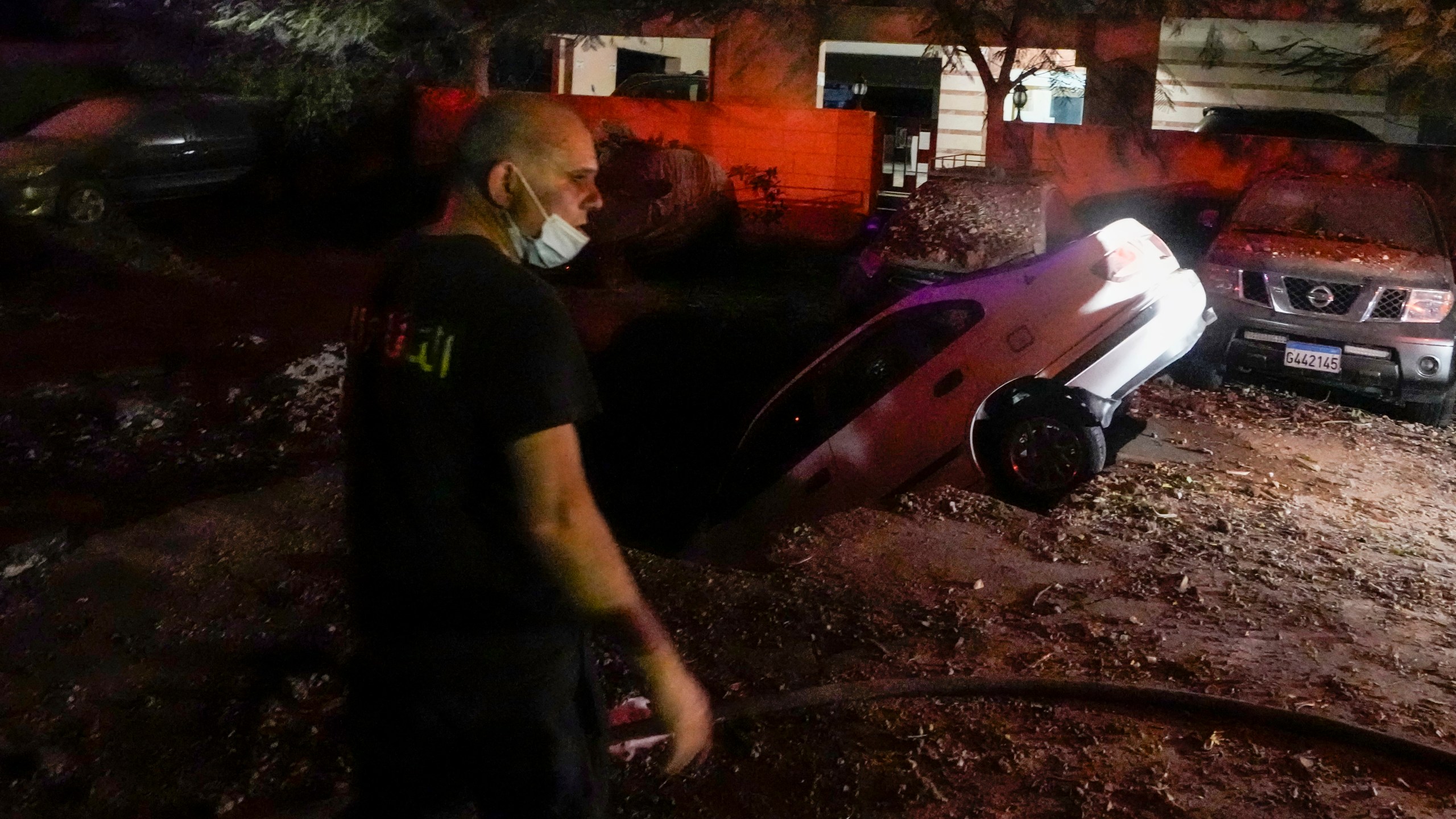 A civil defense member walks at the site of an Israeli airstrike in Beirut's southern suburbs Friday, Sept. 27, 2024. (AP Photo/Bilal Hussein)