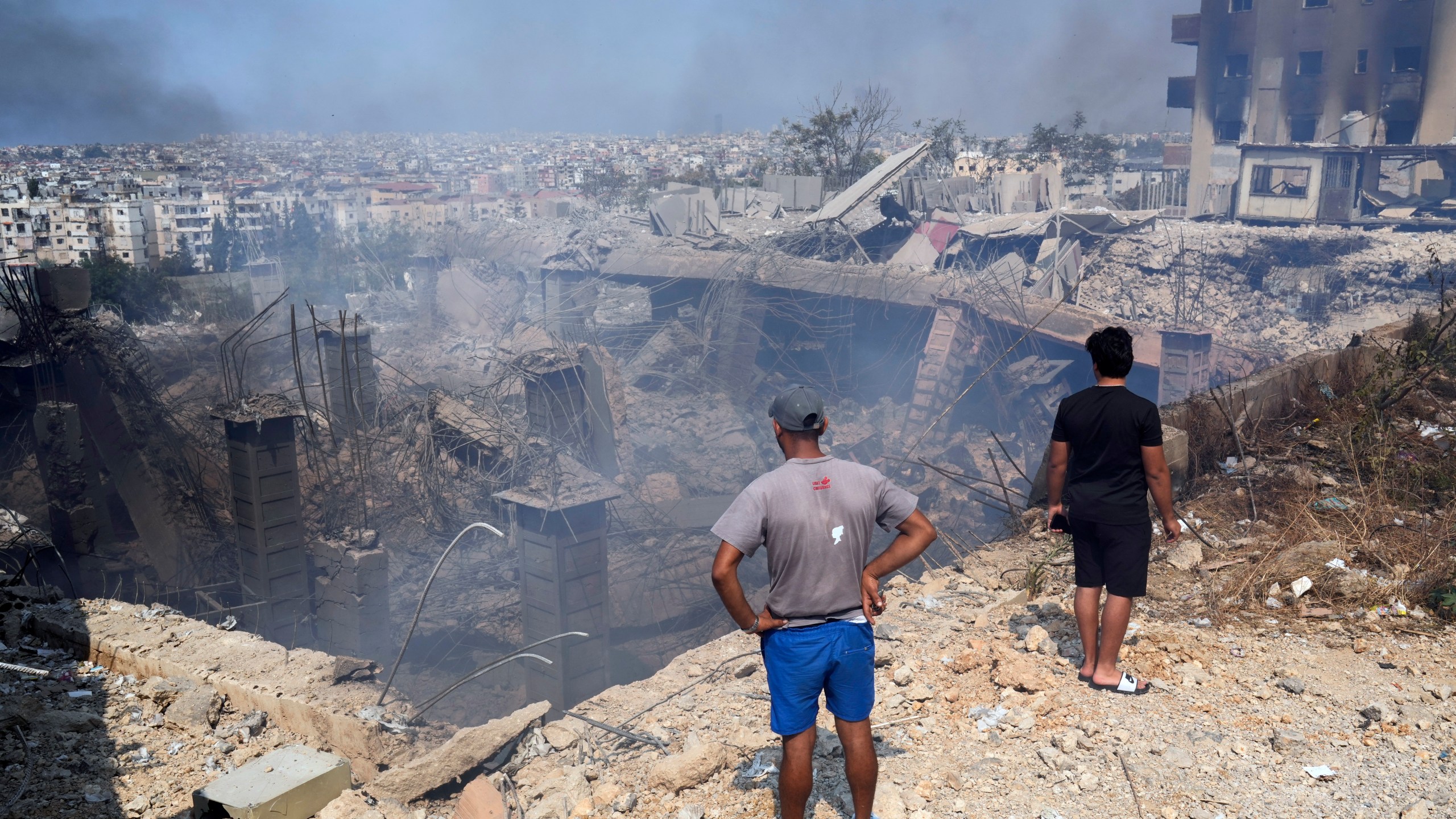 People check a damaged building at the site of an Israeli airstrike in Choueifat, south east of Beirut, Saturday, Sept. 28, 2024. (AP Photo/Hussein Malla)