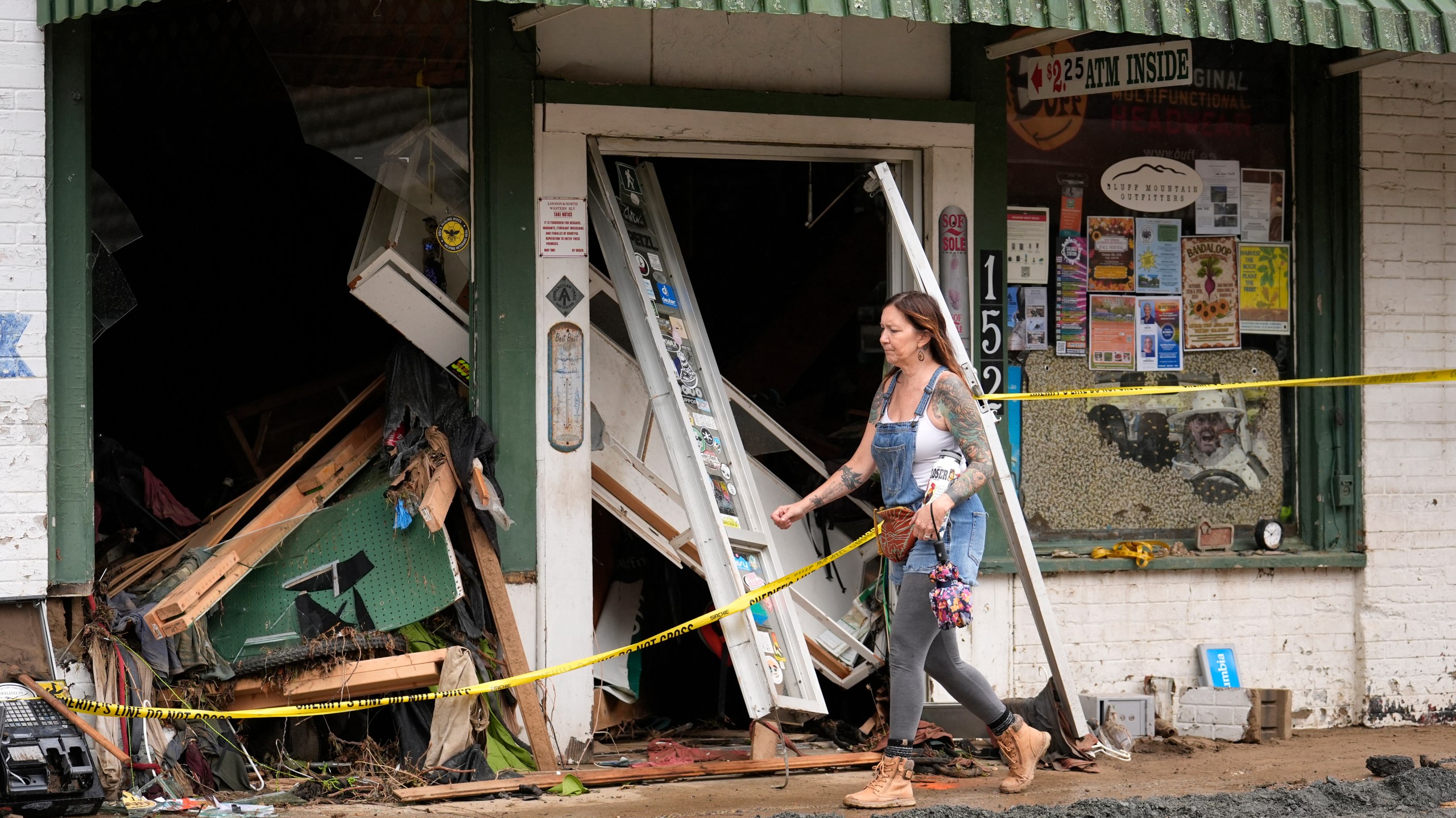 A person walks past a building heavily damaged during Hurricane Helene Tuesday, Oct. 1, 2024, in Hot Springs, N.C. (AP Photo/Jeff Roberson)