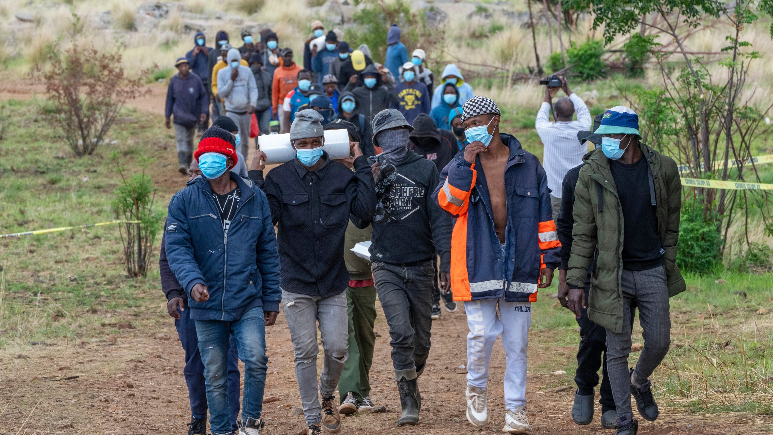 Volunteer rescue workers and community members leave a mine shaft where illegal miners are trapped in a disused mine in Stilfontein, South Africa, Thursday, Nov. 14, 2024. (AP Photo/Jerome Delay)