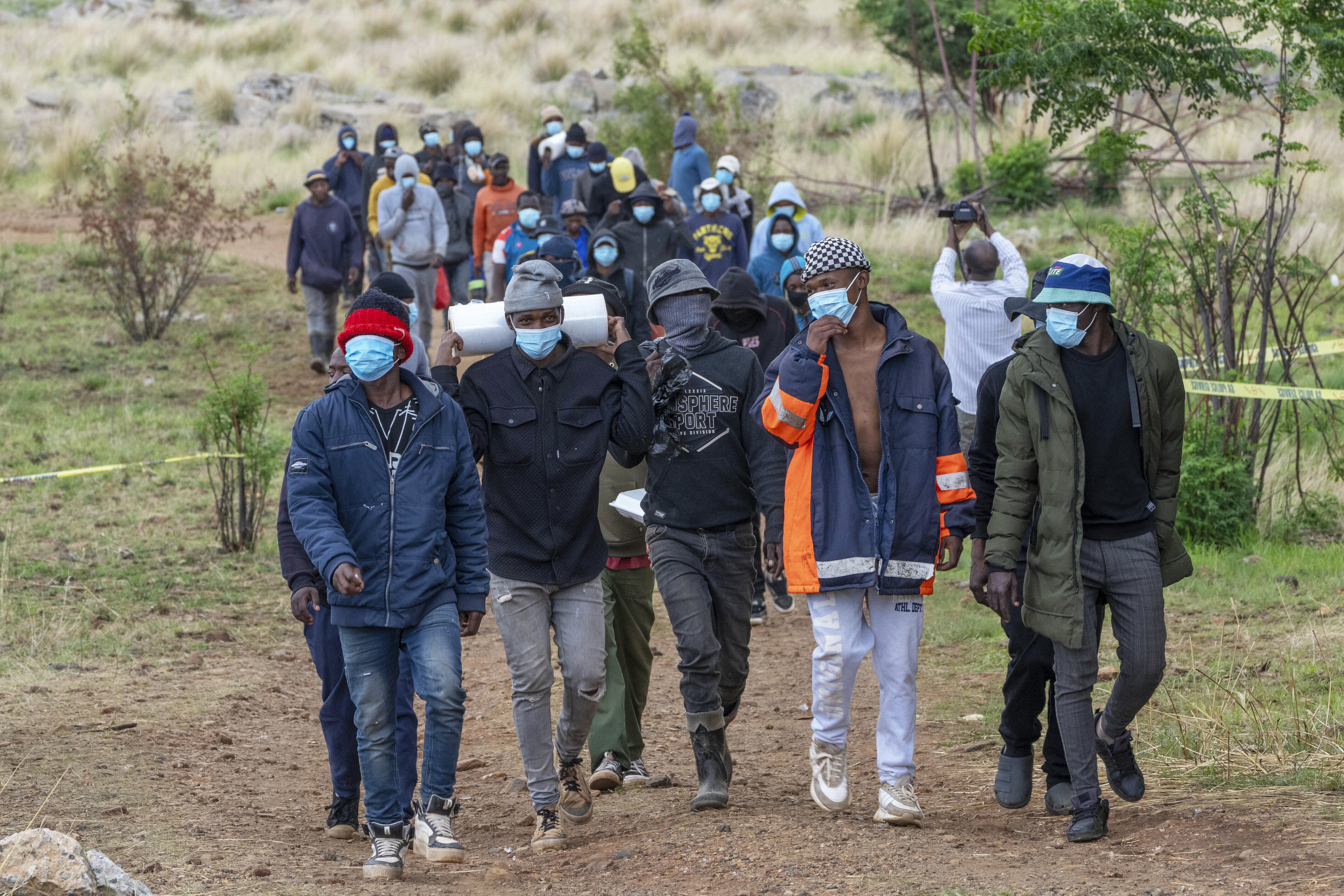 Volunteer rescue workers and community members leave a mine shaft where illegal miners are trapped in a disused mine in Stilfontein, South Africa, Thursday, Nov. 14, 2024. (AP Photo/Jerome Delay)