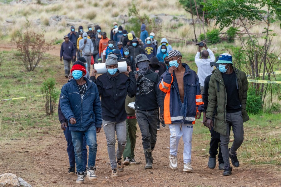 Volunteer rescue workers and community members leave a mine shaft where illegal miners are trapped in a disused mine in Stilfontein, South Africa, Thursday, Nov. 14, 2024. (AP Photo/Jerome Delay)