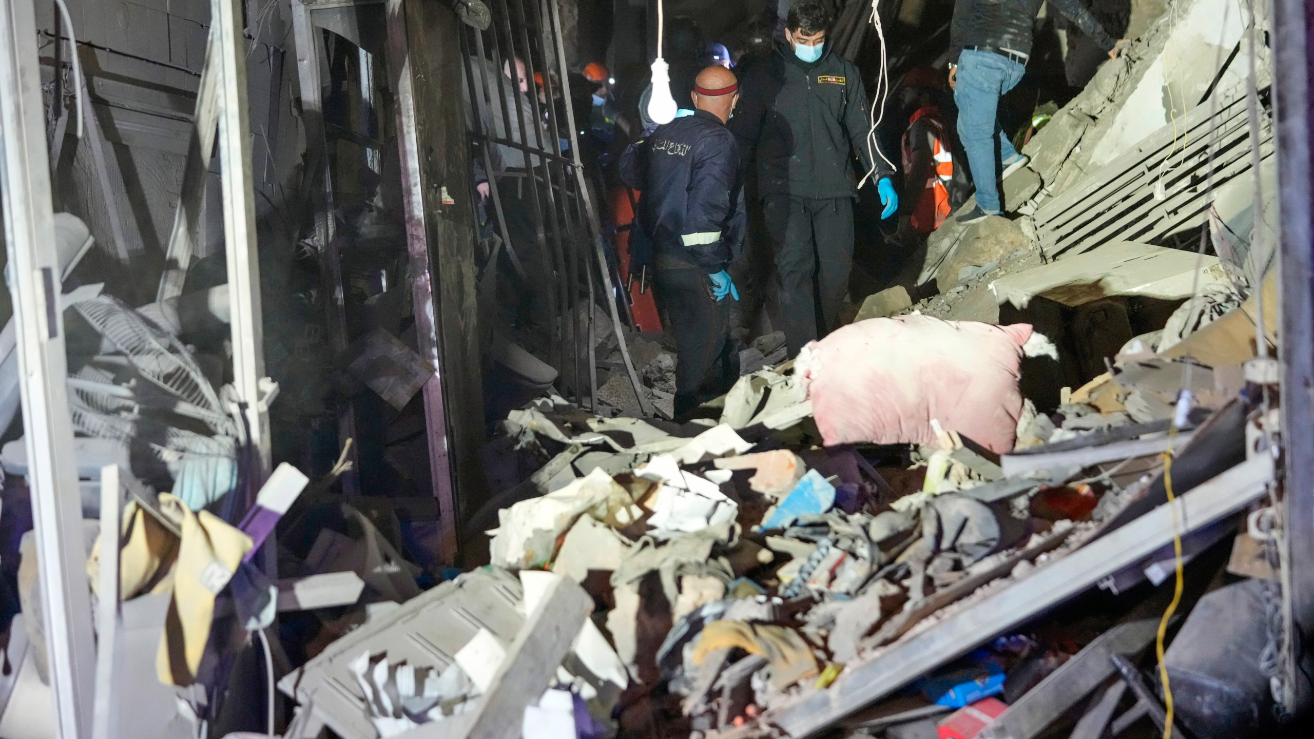 Rescue workers and residents search for victims at the site of an Israeli airstrike in Beirut, Lebanon, Monday, Nov. 18, 2024. (AP Photo/Hussein Malla)