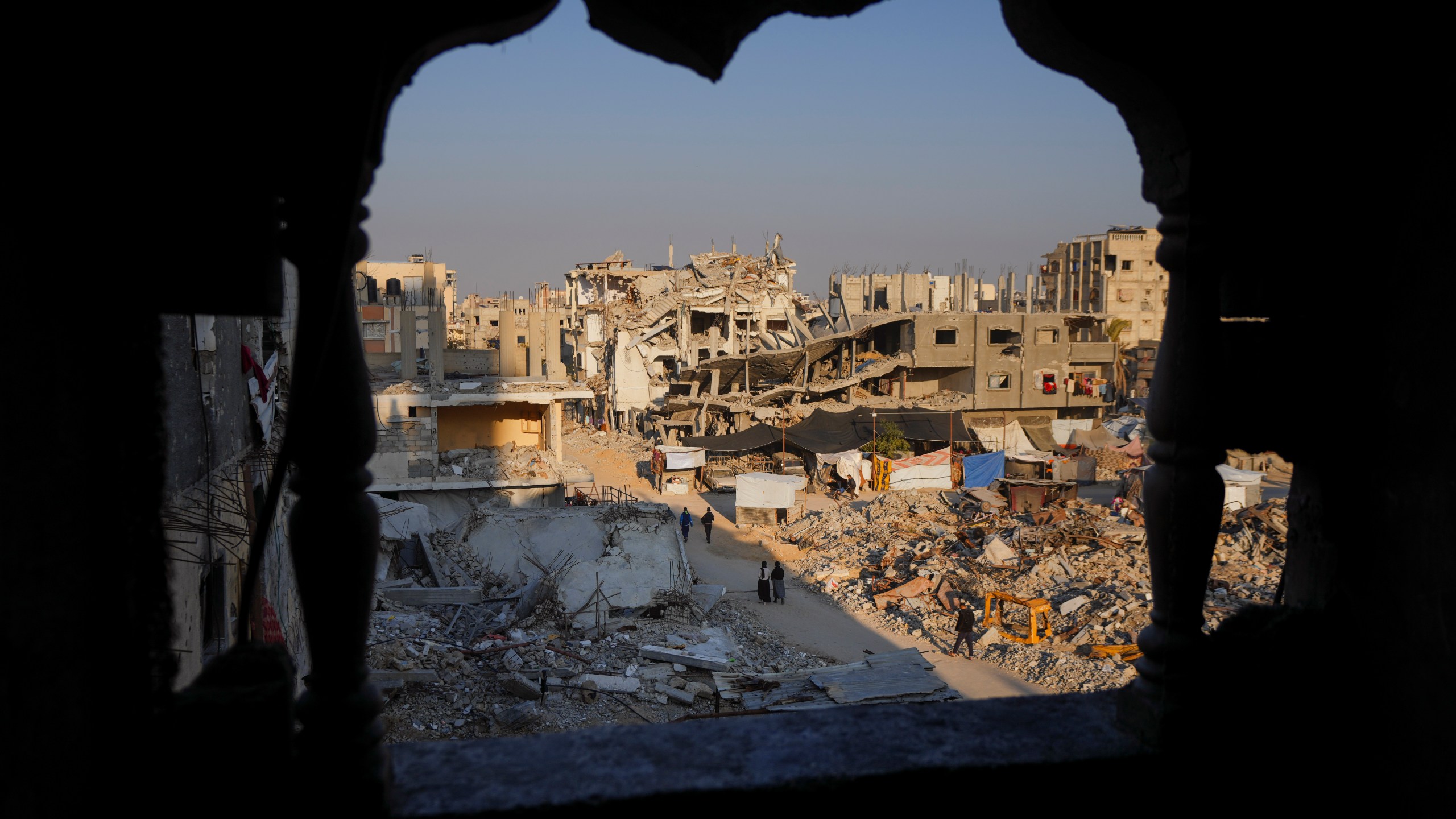 FILE - Palestinians walk through the destruction in the wake of an Israeli air and ground offensive in Khan Younis, southern Gaza Strip, on Jan. 7, 2025. (AP Photo/Abdel Kareem Hana, File)