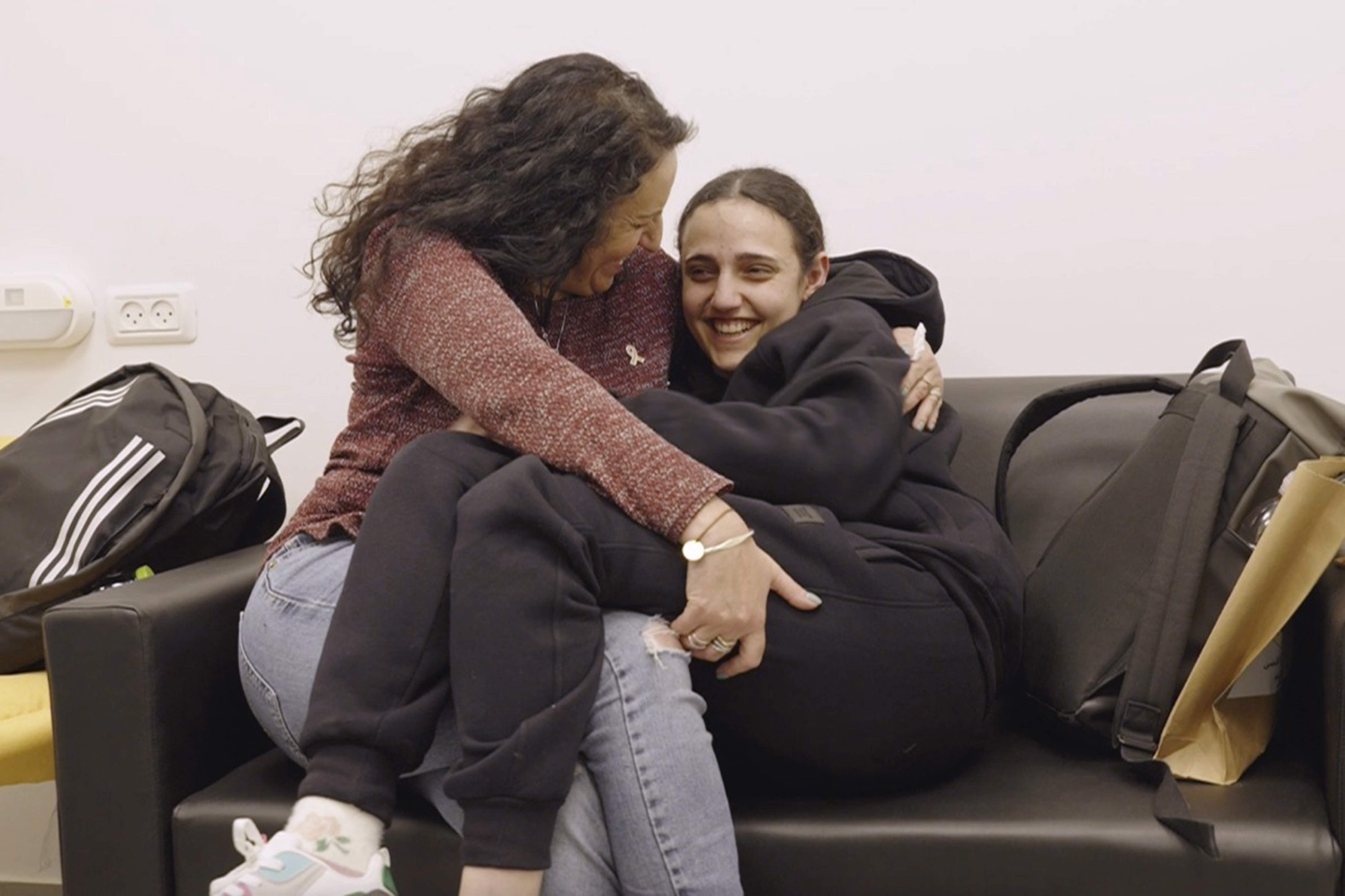 Romi Gonen, right, and her mother Merav hold each other near kibbutz Reim, southern Israel after Romi was released from captivity by Hamas militants in Gaza, Sunday, Jan. 19, 2025. (Israeli Army via AP)