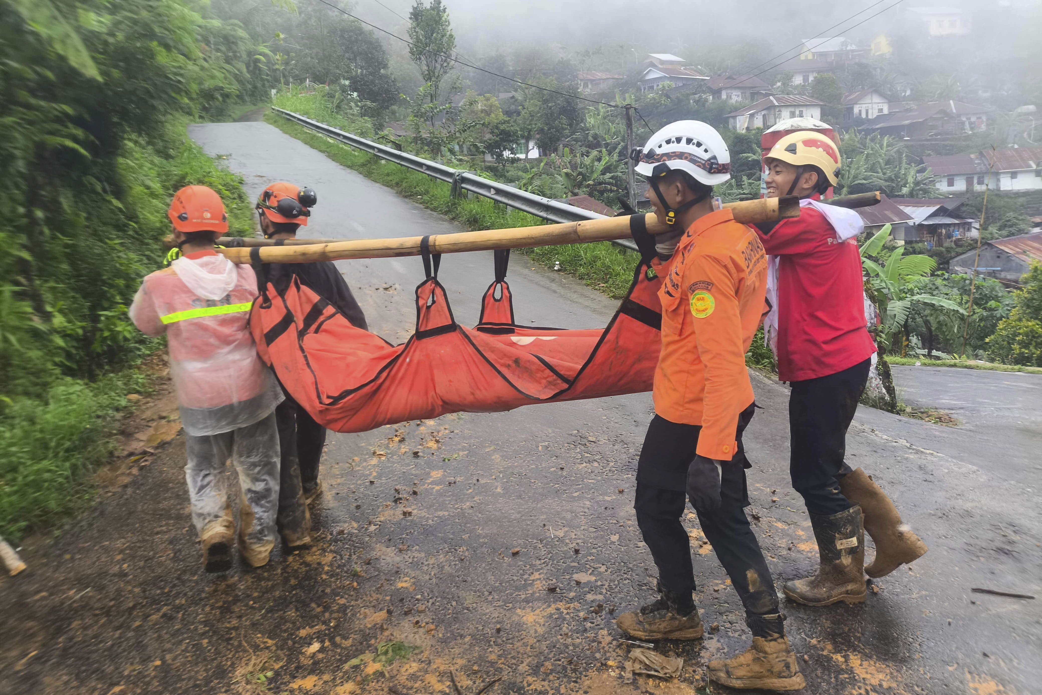 In this undated photo released by Indonesia's National Disaster Management Agency (BNPB) on Wednesday, Jan. 22, 2025, rescuers carry the body of a victim of flash flood which triggered a landslide, in Pekalongan, Central Java, Indonesia. (BNPB via AP)