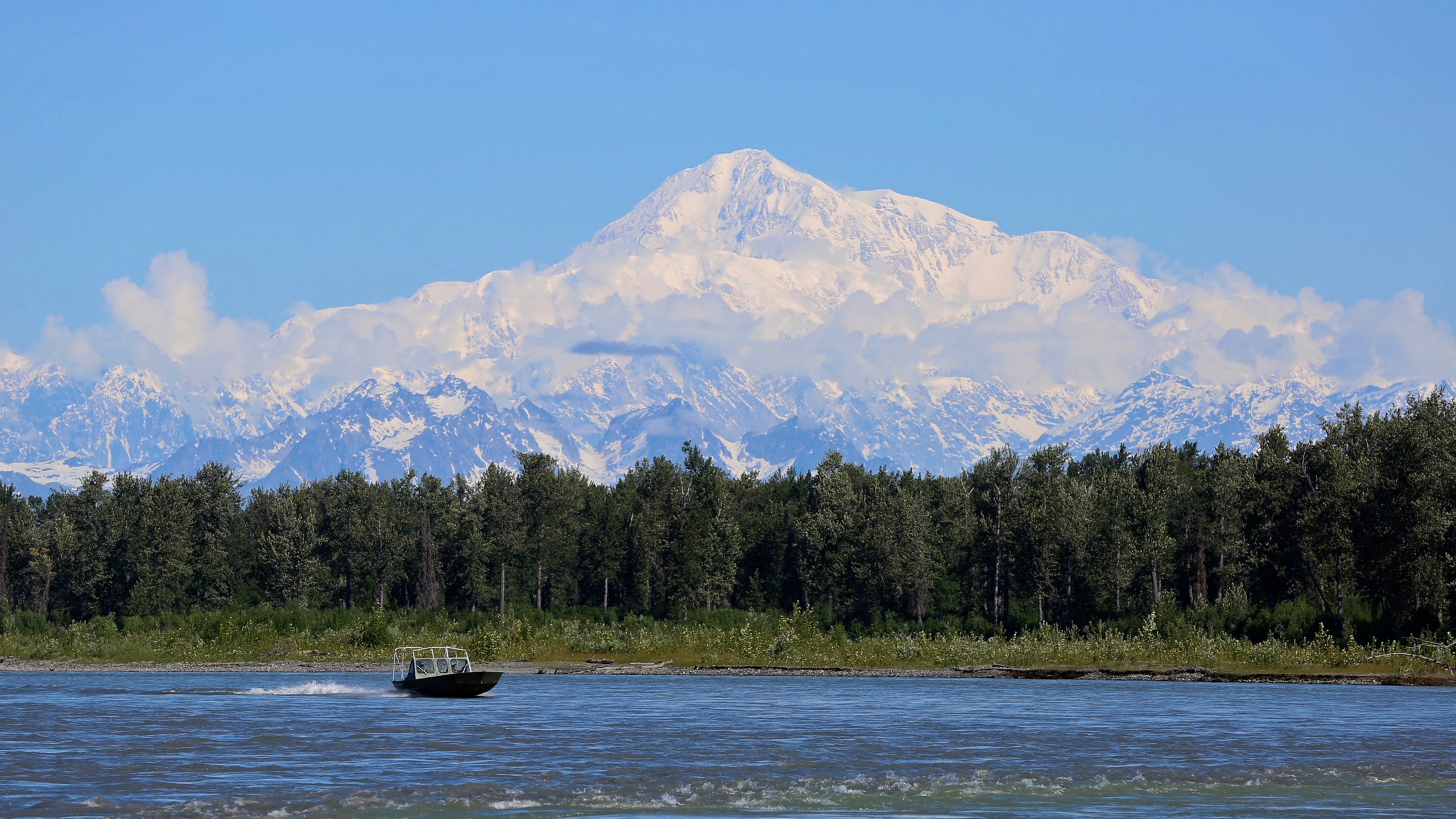 FILE - A boat is seen on the Susitna River near Talkeetna, Alaska, on Sunday, June 13, 2021, with Denali in the background. Denali, the tallest mountain on the North American continent, is located about 60 miles northwest of Talkeetna. (AP Photo/Mark Thiessen, File)