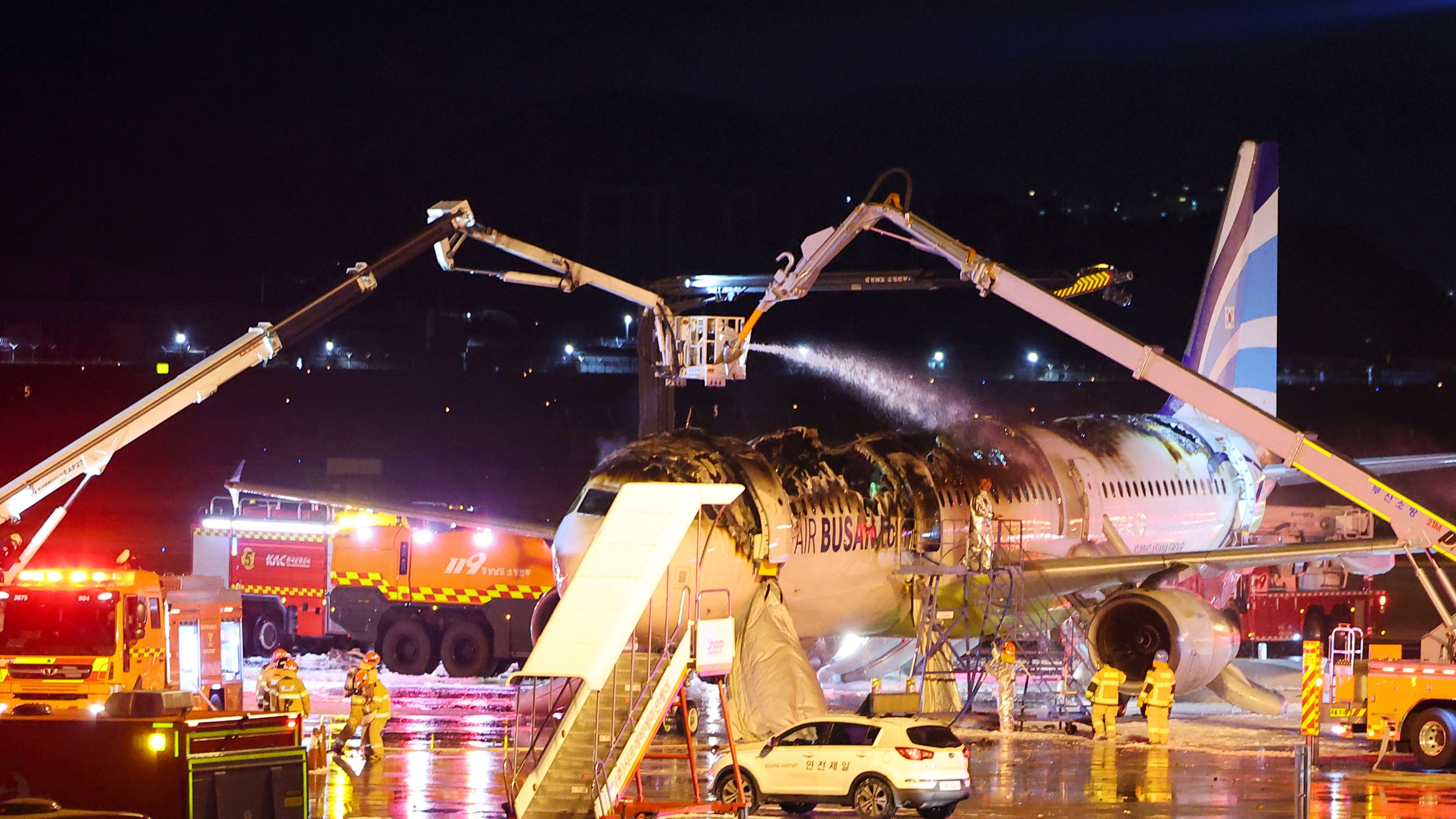 Firefighters work to extinguish a fire on an Air Busan airplane at Gimhae International Airport in Busan, South Korea, Tuesday, Jan. 28, 2025. (Son Hyung-joo/Yonhap via AP)