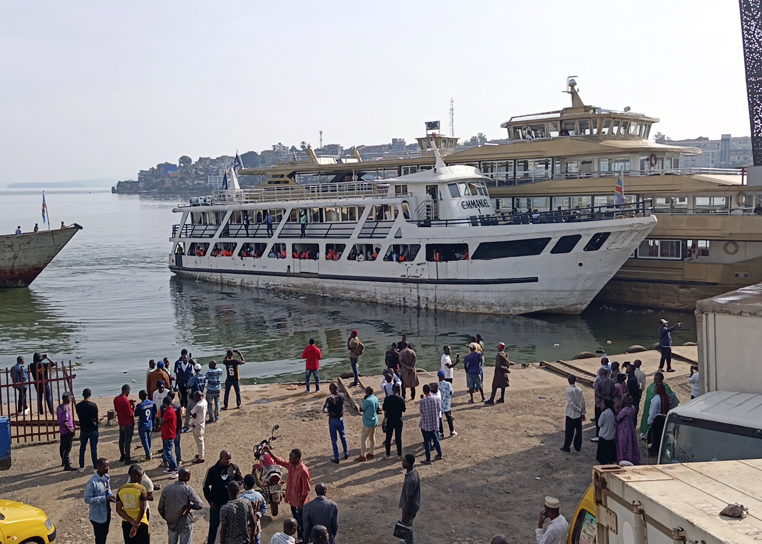 People watch the first boat leaving Bukavu heading to Goma on Lake Kivu since the eastern Congo city was taken by M23 rebels Tuesday, Feb. 18, 2025. (AP Photo/Janvier Barhahiga)