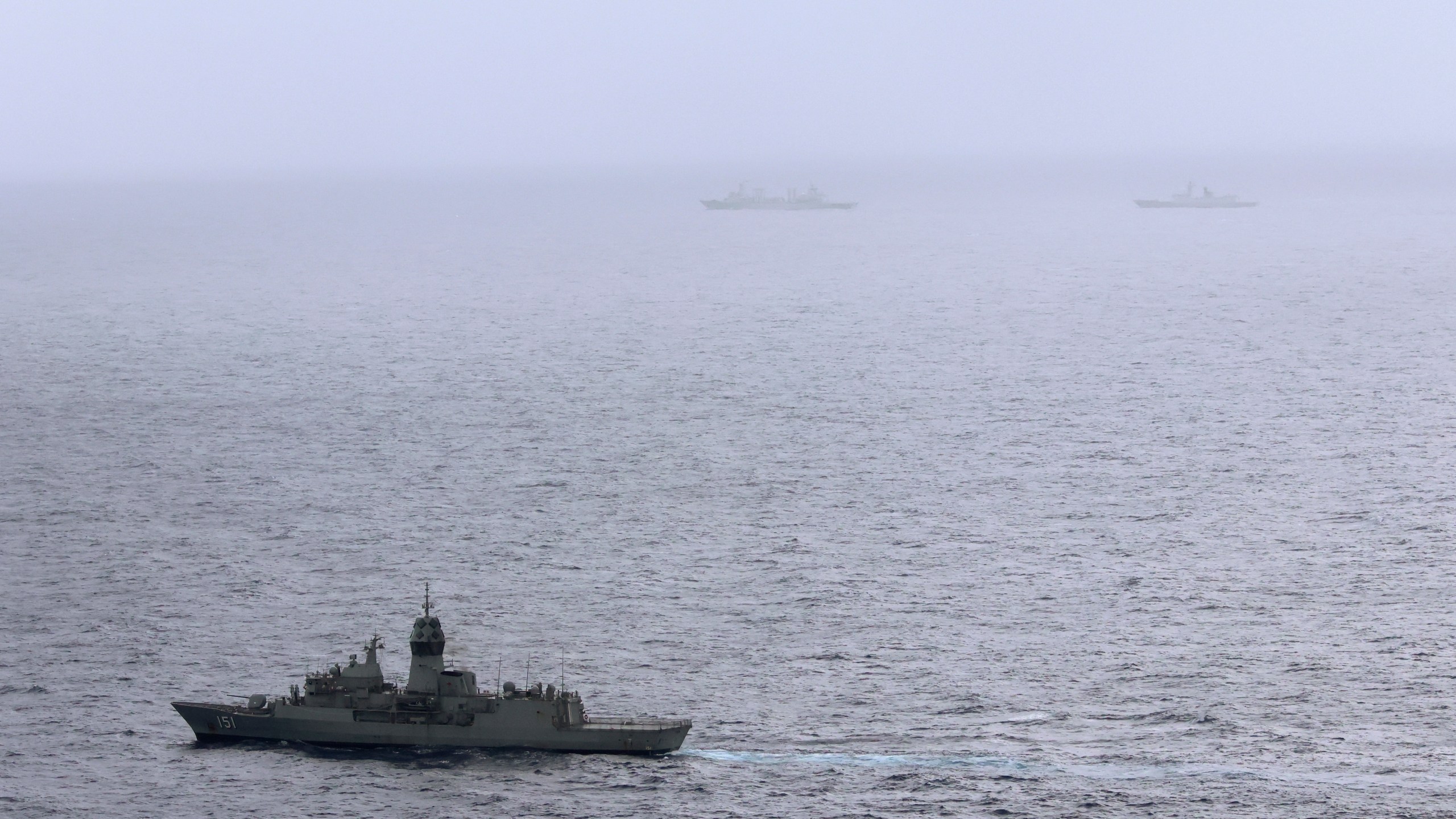 In this photo provided by the Australian Defense Force, the HMAS (His Majesty's Australian Ship) Arunta, left, shadows the People's Liberation Army-Navy Jiangkai-class frigate Hengyang and a Fuchi-class replenishment vessel in the Tasman Sea, on Feb. 13, 2025. (Australian Defense Force via AP)