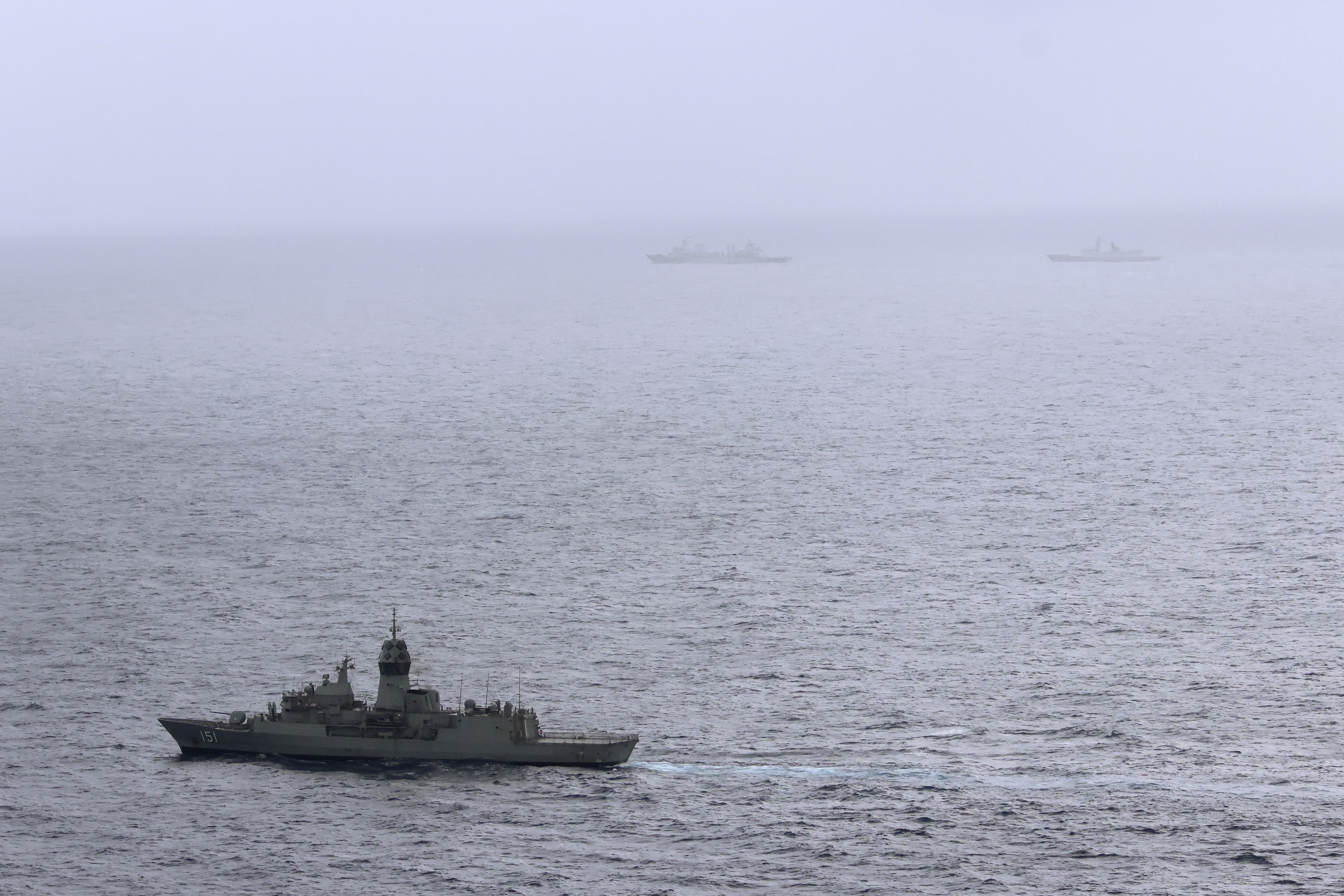 In this photo provided by the Australian Defense Force, the HMAS (His Majesty's Australian Ship) Arunta, left, shadows the People's Liberation Army-Navy Jiangkai-class frigate Hengyang and a Fuchi-class replenishment vessel in the Tasman Sea, on Feb. 13, 2025. (Australian Defense Force via AP)