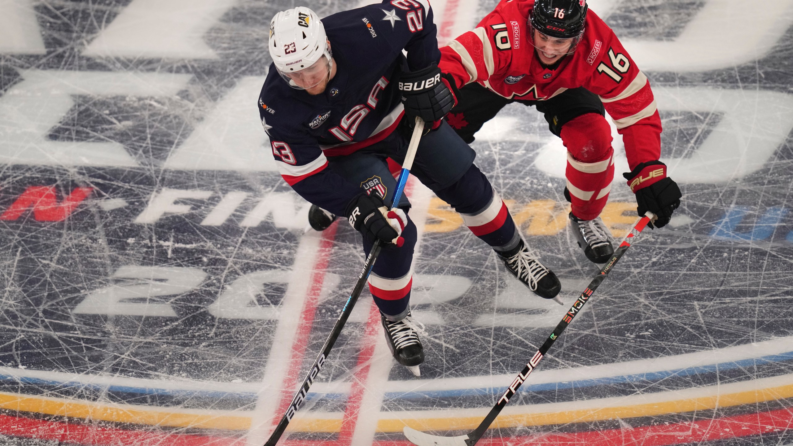 United States' Adam Fox, left, battles Canada's Mitch Marner for the puck during the first period of the 4 Nations Face-Off championship hockey game, Thursday, Feb. 20, 2025, in Boston. (AP Photo/Charles Krupa)