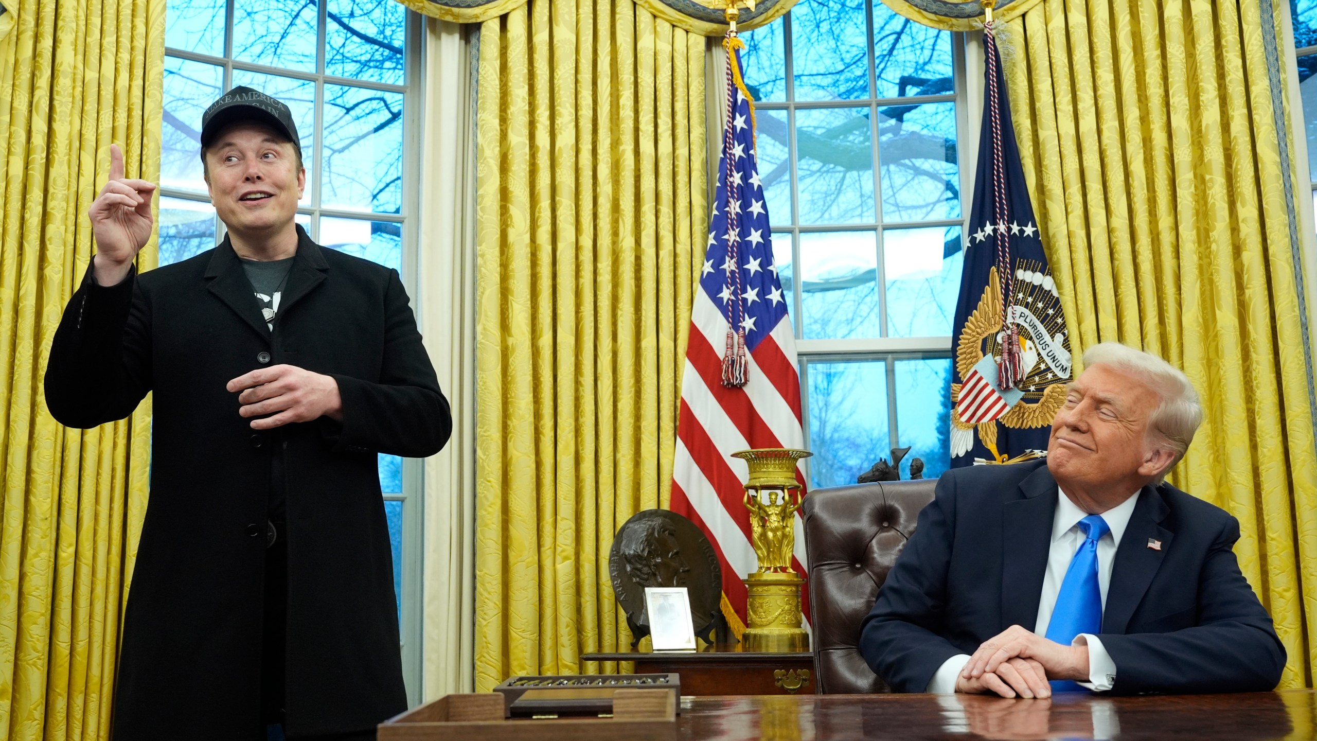 President Donald Trump listens as Elon Musk speaks in the Oval Office at the White House, Tuesday, Feb. 11, 2025, in Washington. (AP Photo/Alex Brandon)