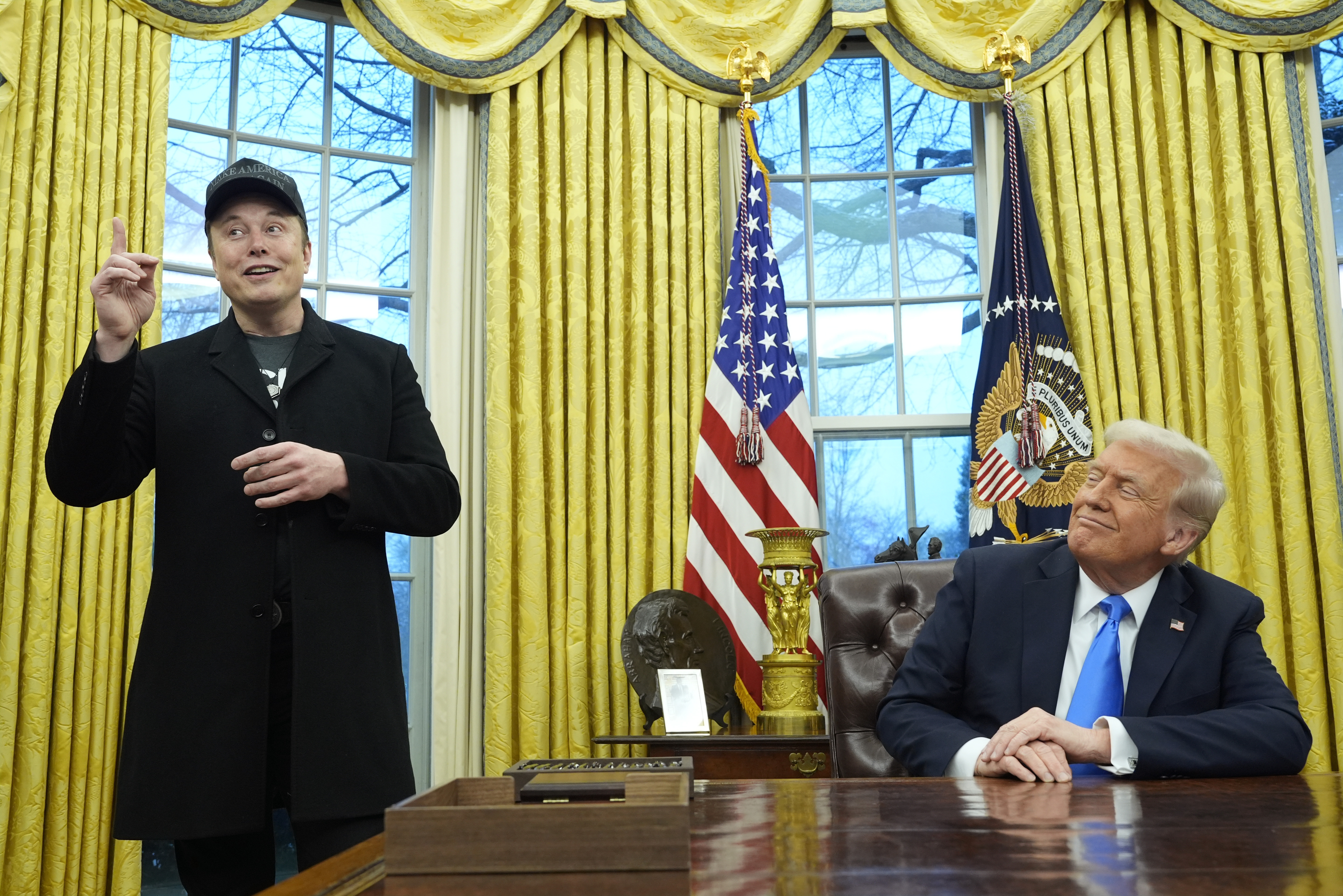 President Donald Trump listens as Elon Musk speaks in the Oval Office at the White House, Tuesday, Feb. 11, 2025, in Washington. (AP Photo/Alex Brandon)