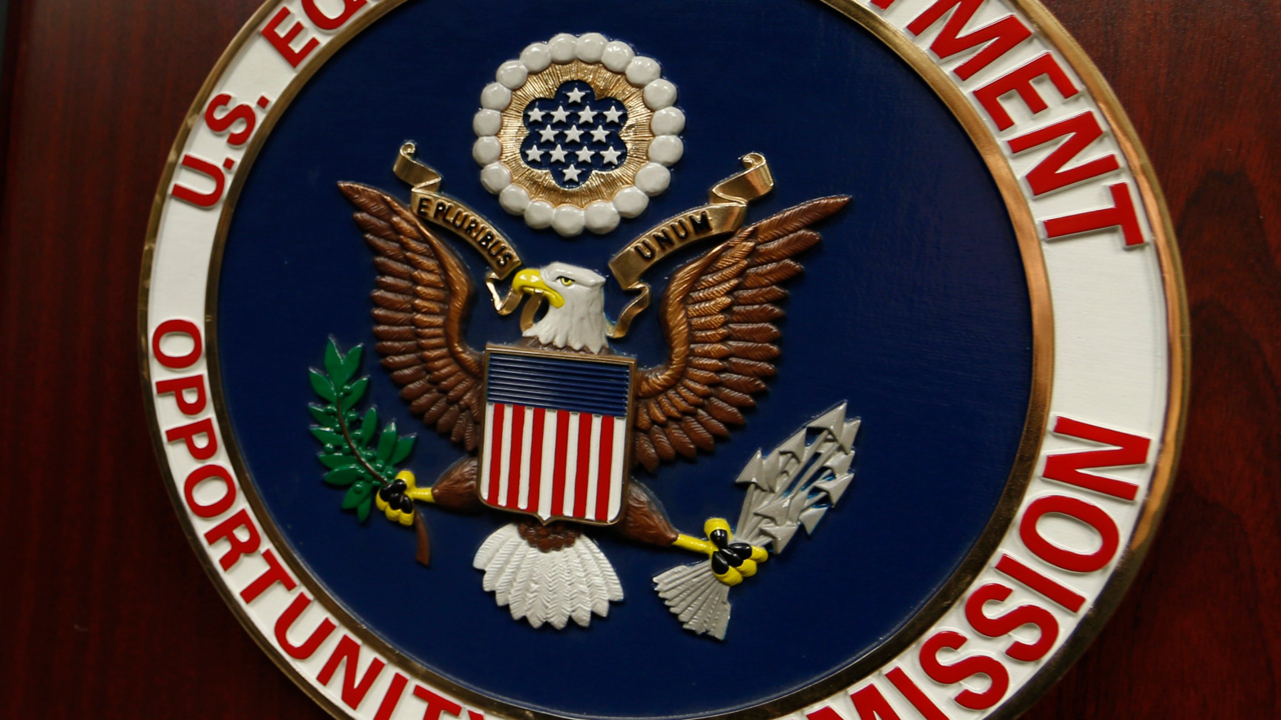 FILE - The emblem of the U.S. Equal Employment Opportunity Commission (EEOC) is shown on a podium in Vail, Colorado, Feb. 16, 2016, in Denver. (AP Photo/David Zalubowski, File)