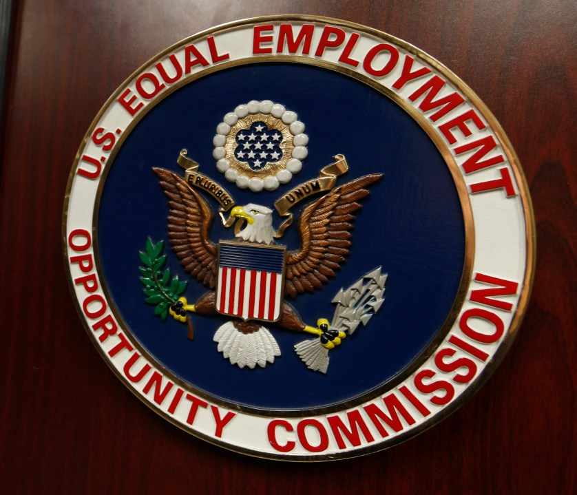 FILE - The emblem of the U.S. Equal Employment Opportunity Commission (EEOC) is shown on a podium in Vail, Colorado, Feb. 16, 2016, in Denver. (AP Photo/David Zalubowski, File)