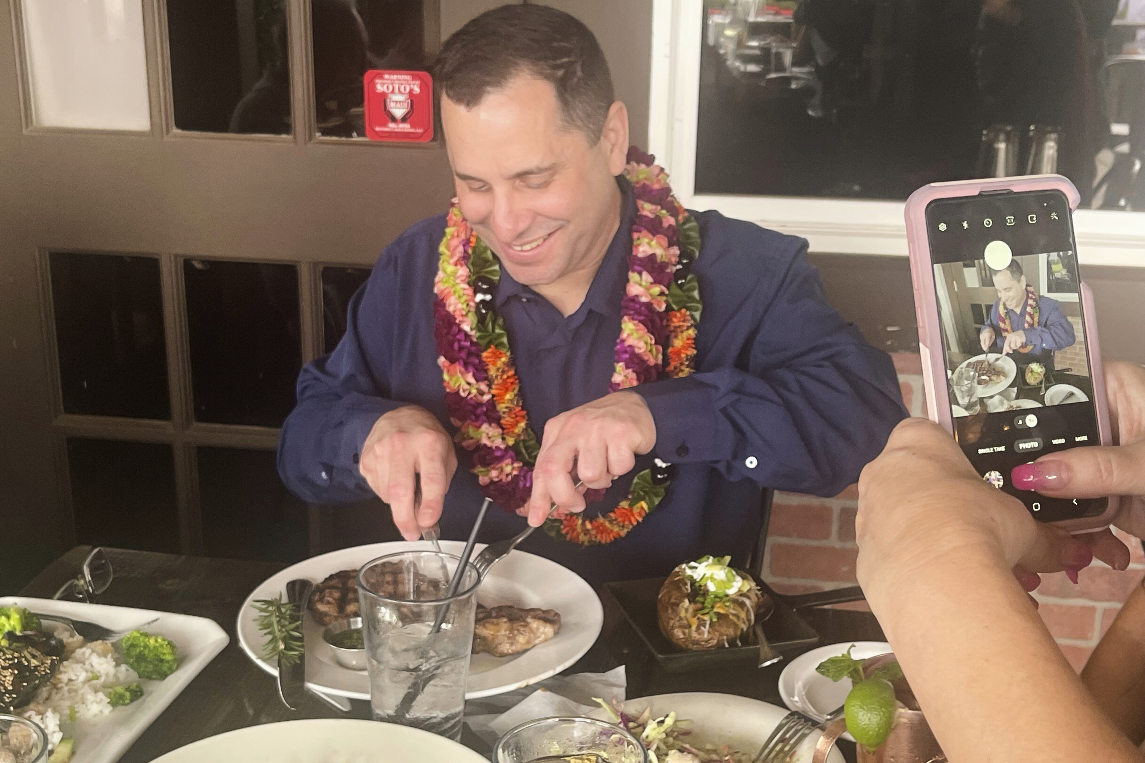 In this photo provided by Kenneth Lawson, Gordon Cordeiro, who spent 30 years in prison for a murder he said he didn't commit, enjoys dinner at a steak house Friday, Feb. 21, 2025, in Kahului, Hawaii, hours after a judge ordered him released because of new evidence. (Kenneth Lawson via AP)