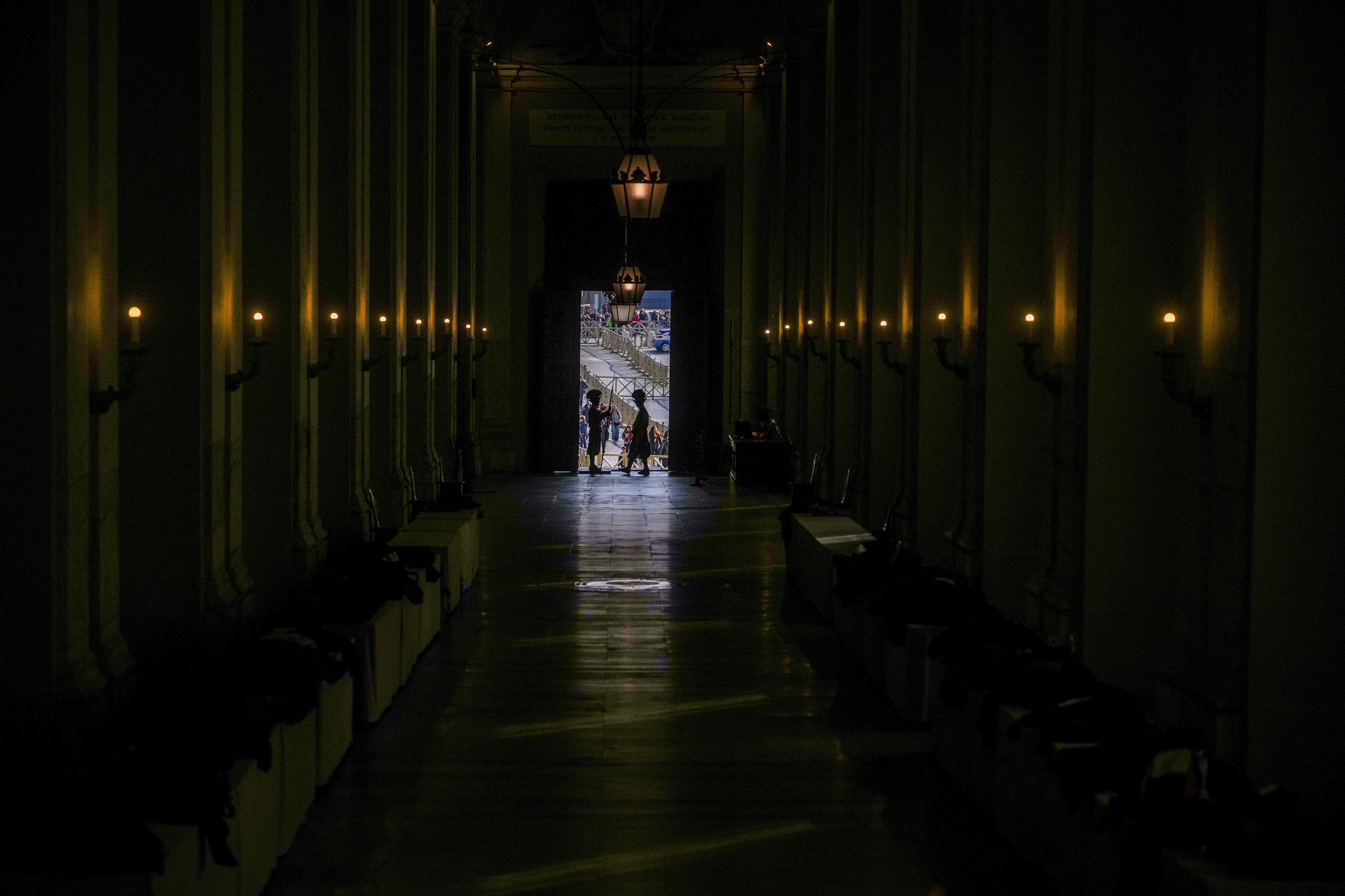 Vatican Swiss guards surveil the Bronze Door, the main entrance to the papal apartments, at The Vatican, Sunday, Feb. 23, 2025, as Pope Francis who was admitted over a week ago at Rome's Agostino Gemelli Polyclinic is in critical conditions. (AP Photo/Alessandra Tarantino)