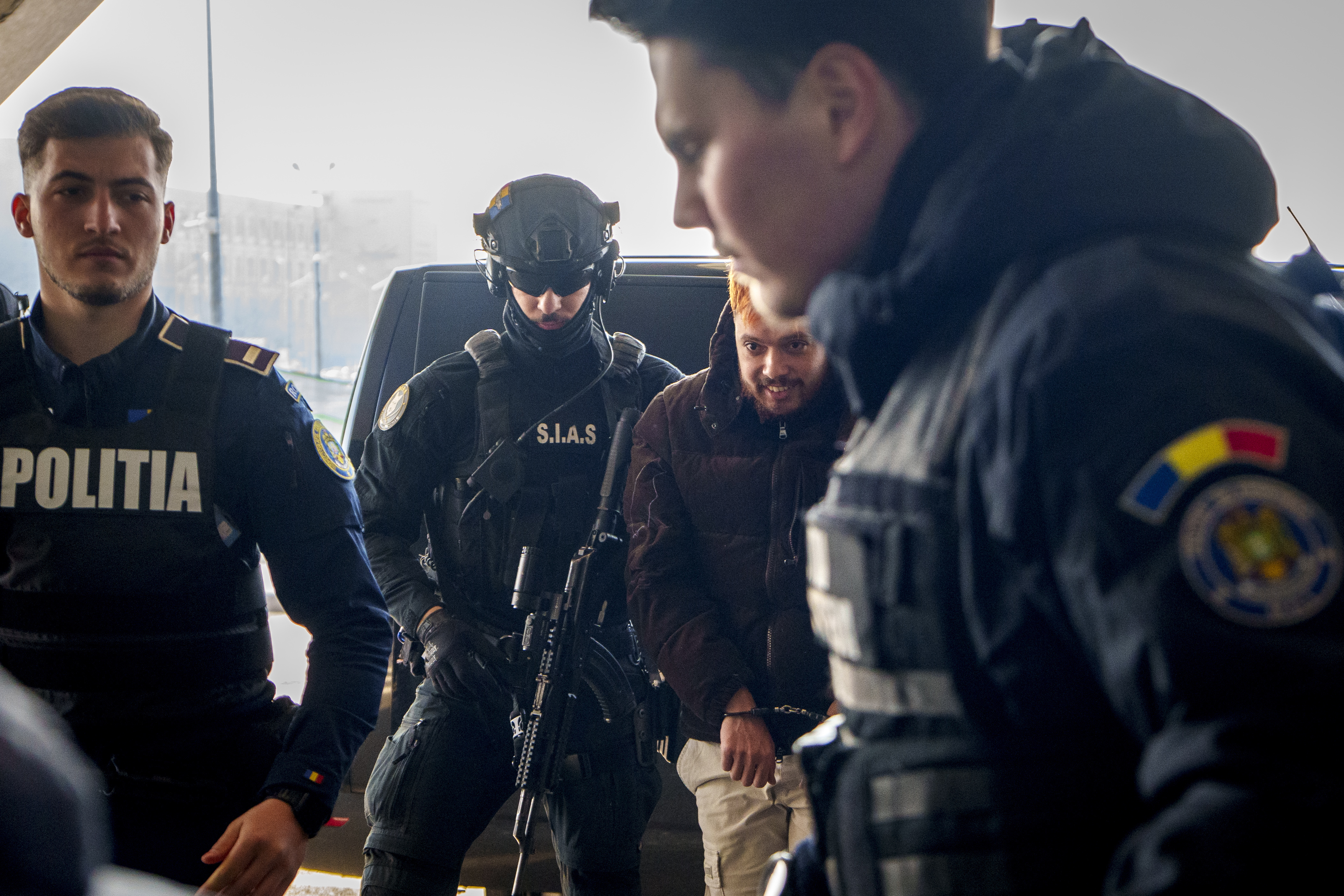 Mohamed Amra, nicknamed ''The Fly", is escorted by armed police officers at the Henri Coanda international airport in Otopeni, Romania, Tuesday, Feb. 25, 2025, before being extradited to France. (AP Photo/Vadim Ghirda)