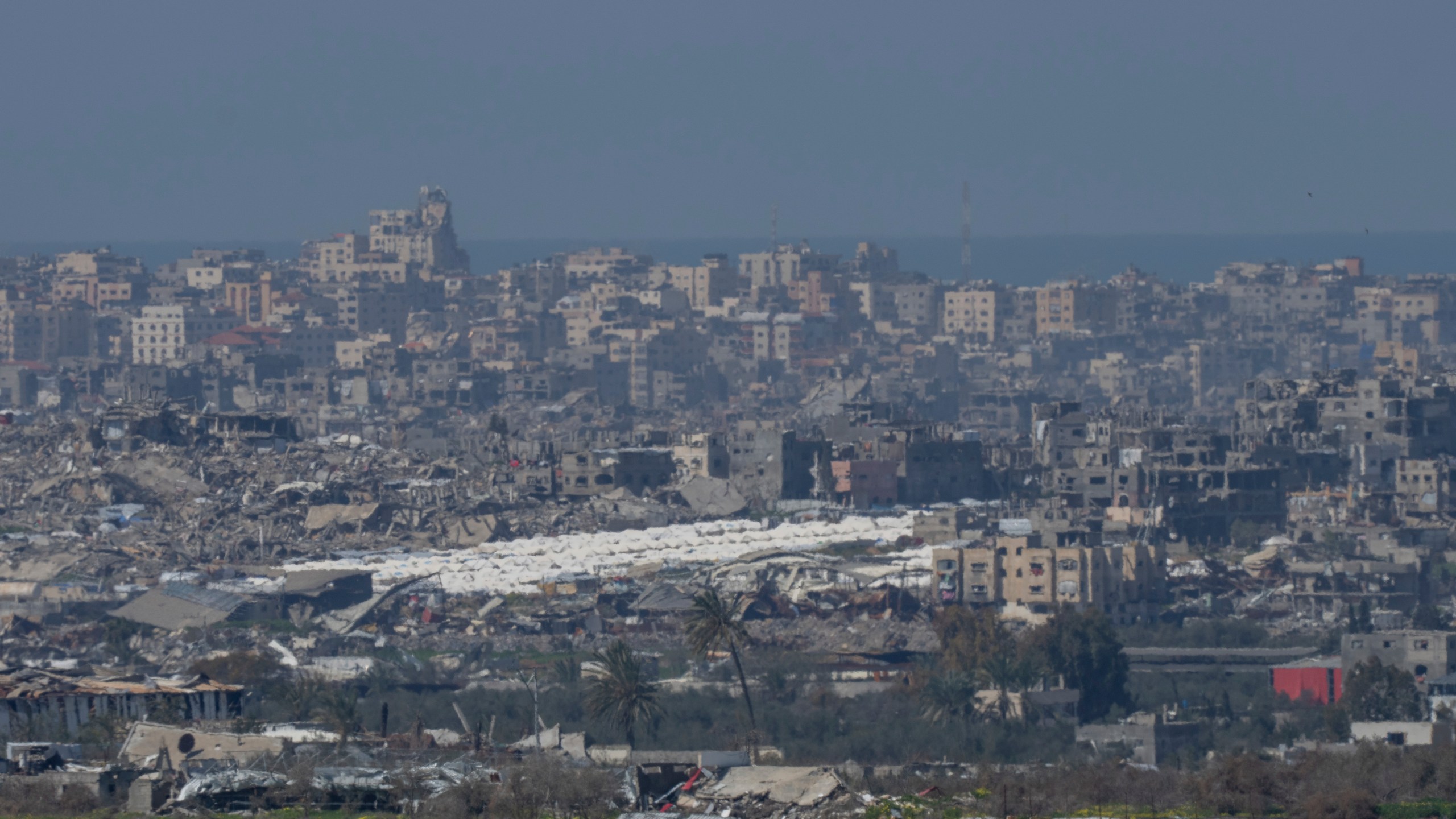 Tents are seen among the destroyed buildings in the Gaza Strip as seen from southern Israel, Tuesday, Feb. 25, 2025. (AP Photo/Ohad Zwigenberg)