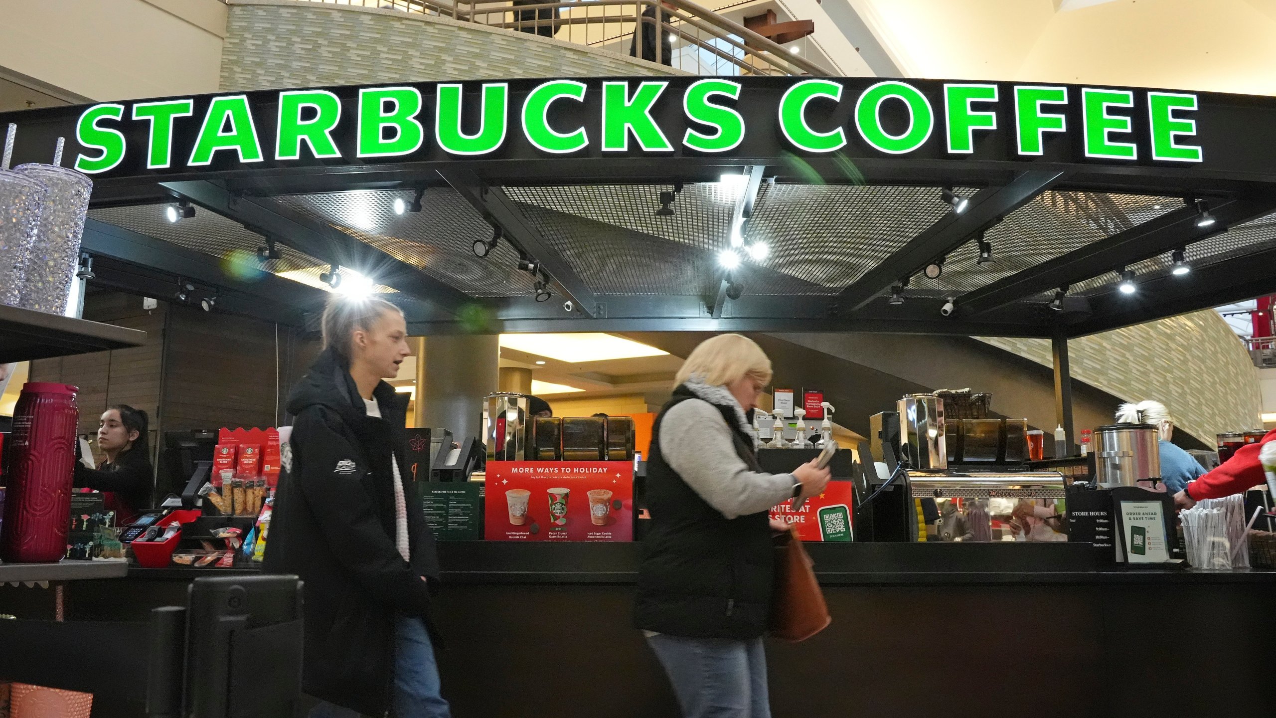 FILE - Shoppers at the Walden Galleria in Buffalo, NY, stop by the Starbucks kiosk on Saturday, Nov. 30, 2024. (AP Photo/Gene J. Puskar, File)