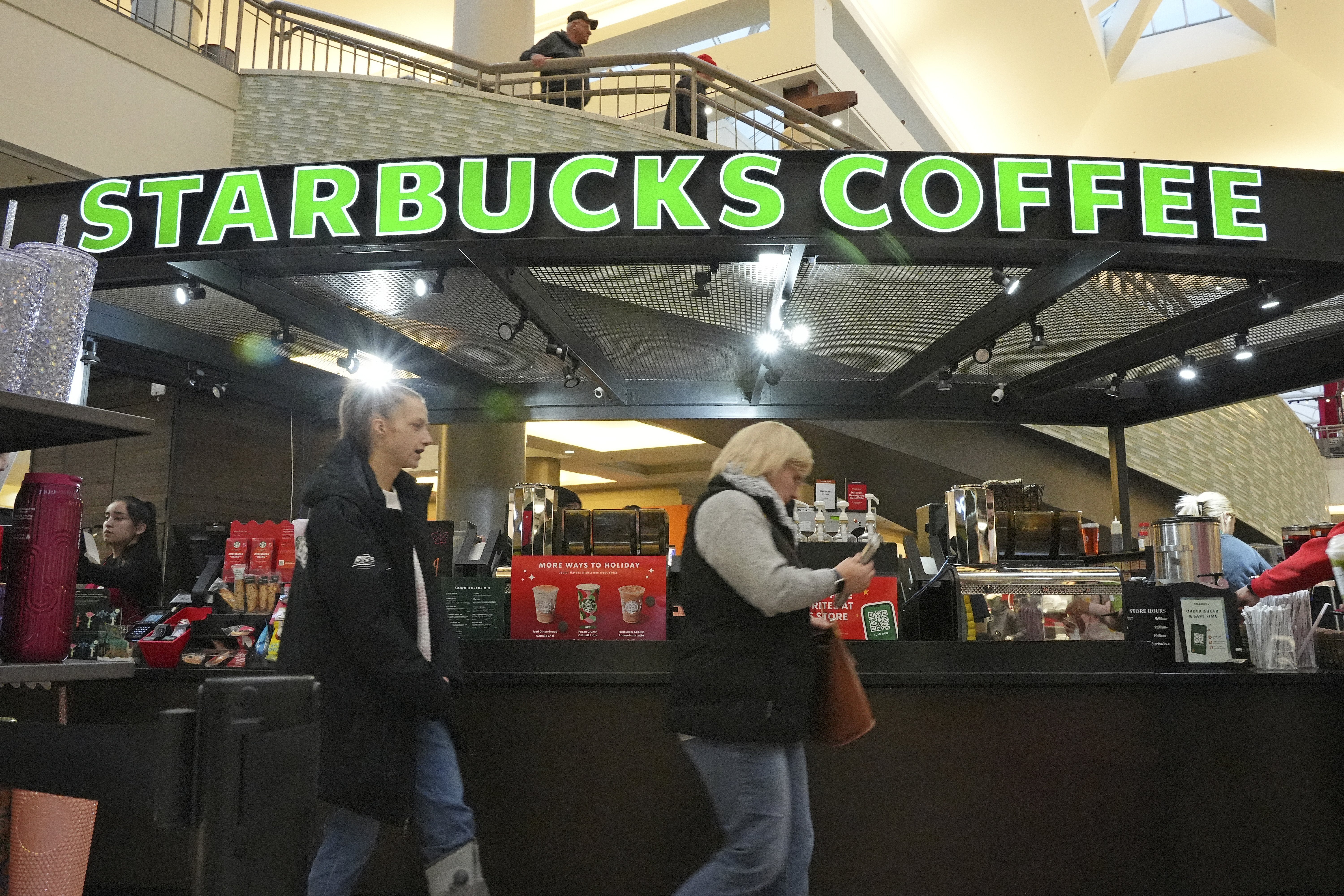 FILE - Shoppers at the Walden Galleria in Buffalo, NY, stop by the Starbucks kiosk on Saturday, Nov. 30, 2024. (AP Photo/Gene J. Puskar, File)