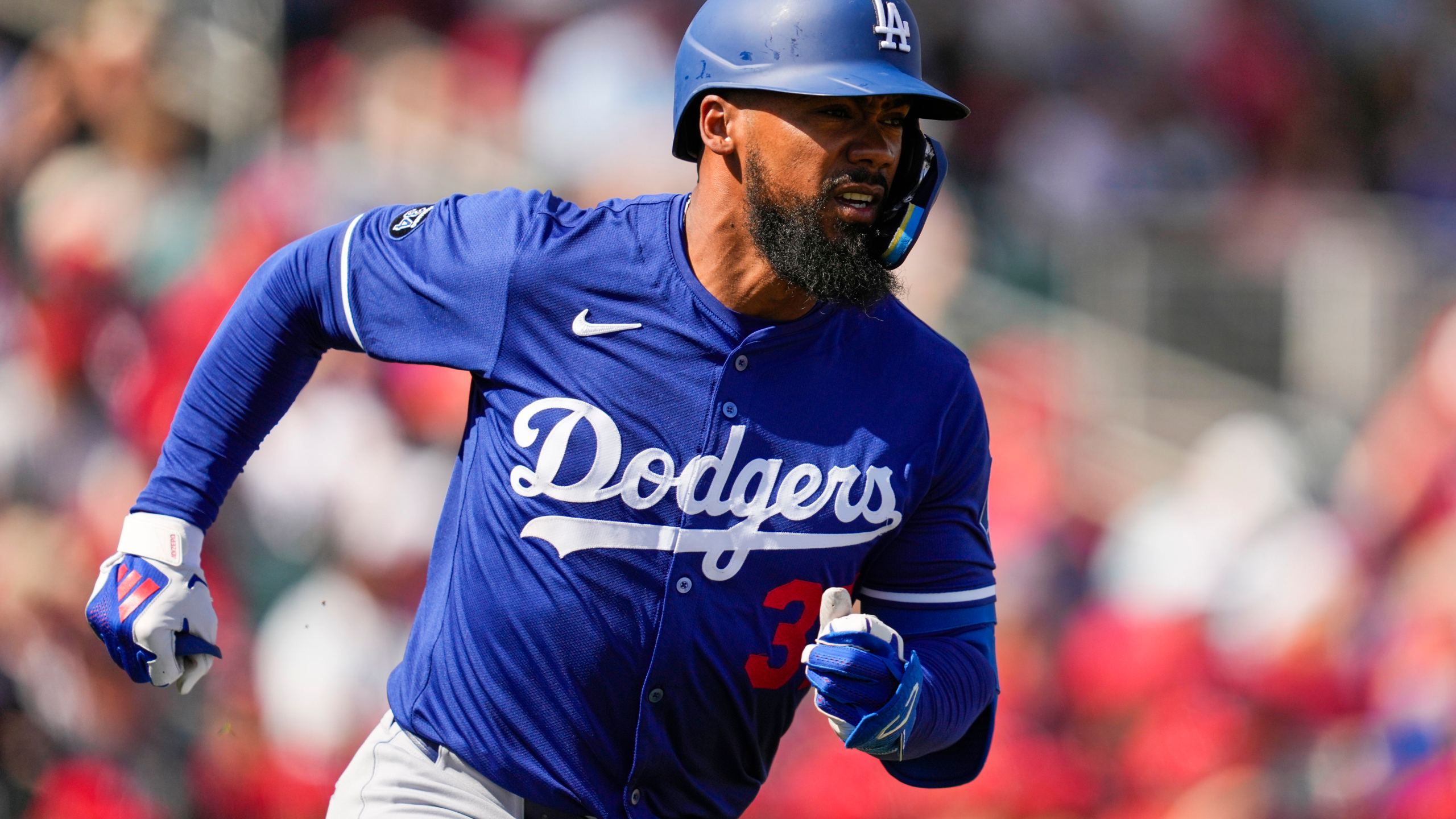 Los Angeles Dodgers' Teoscar Hernandez runs to first on a single during the first inning of a spring training baseball game against the Cincinnati Reds, Monday, Feb. 24, 2025, in Goodyear, Ariz. (AP Photo/Ashley Landis)