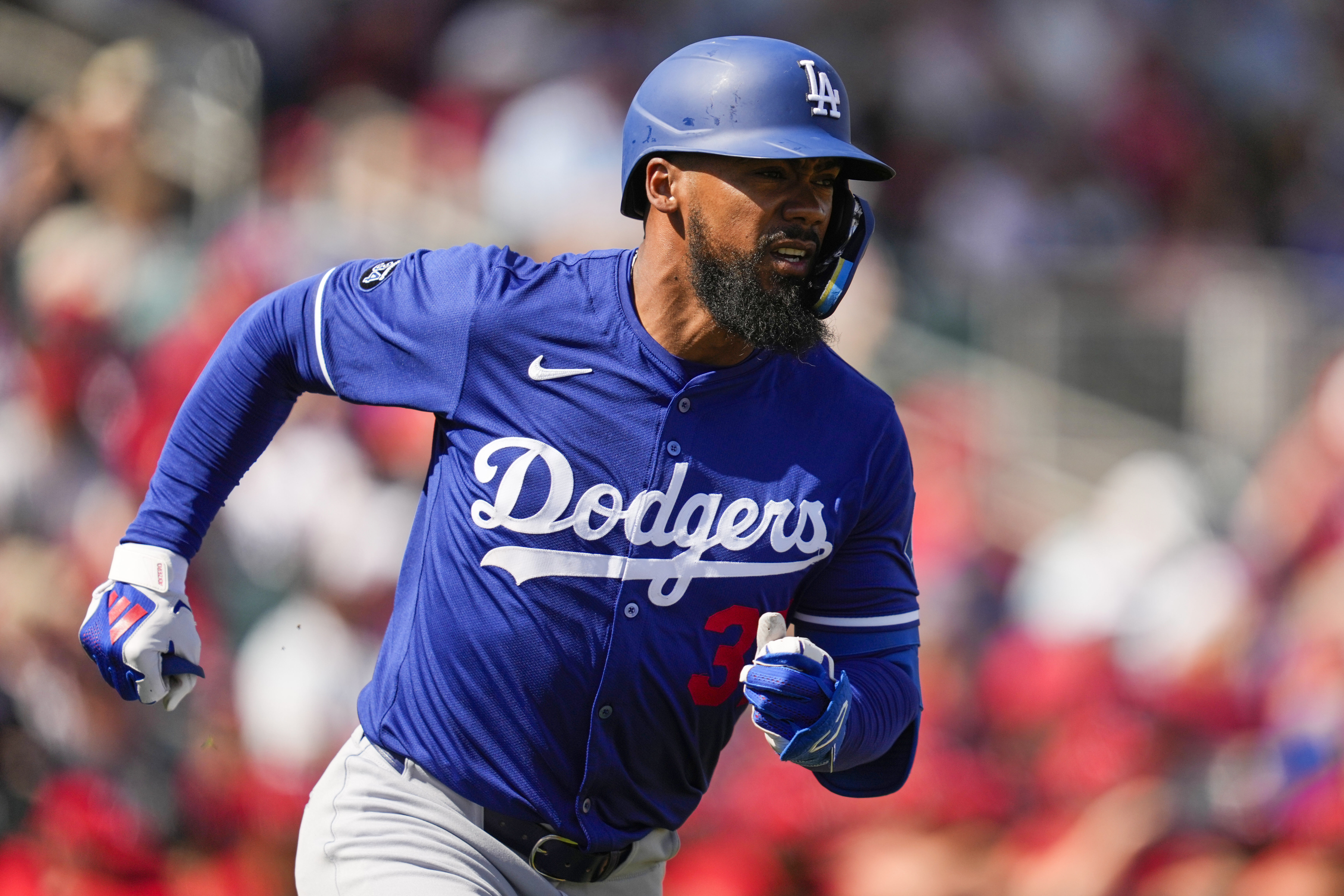 Los Angeles Dodgers' Teoscar Hernandez runs to first on a single during the first inning of a spring training baseball game against the Cincinnati Reds, Monday, Feb. 24, 2025, in Goodyear, Ariz. (AP Photo/Ashley Landis)