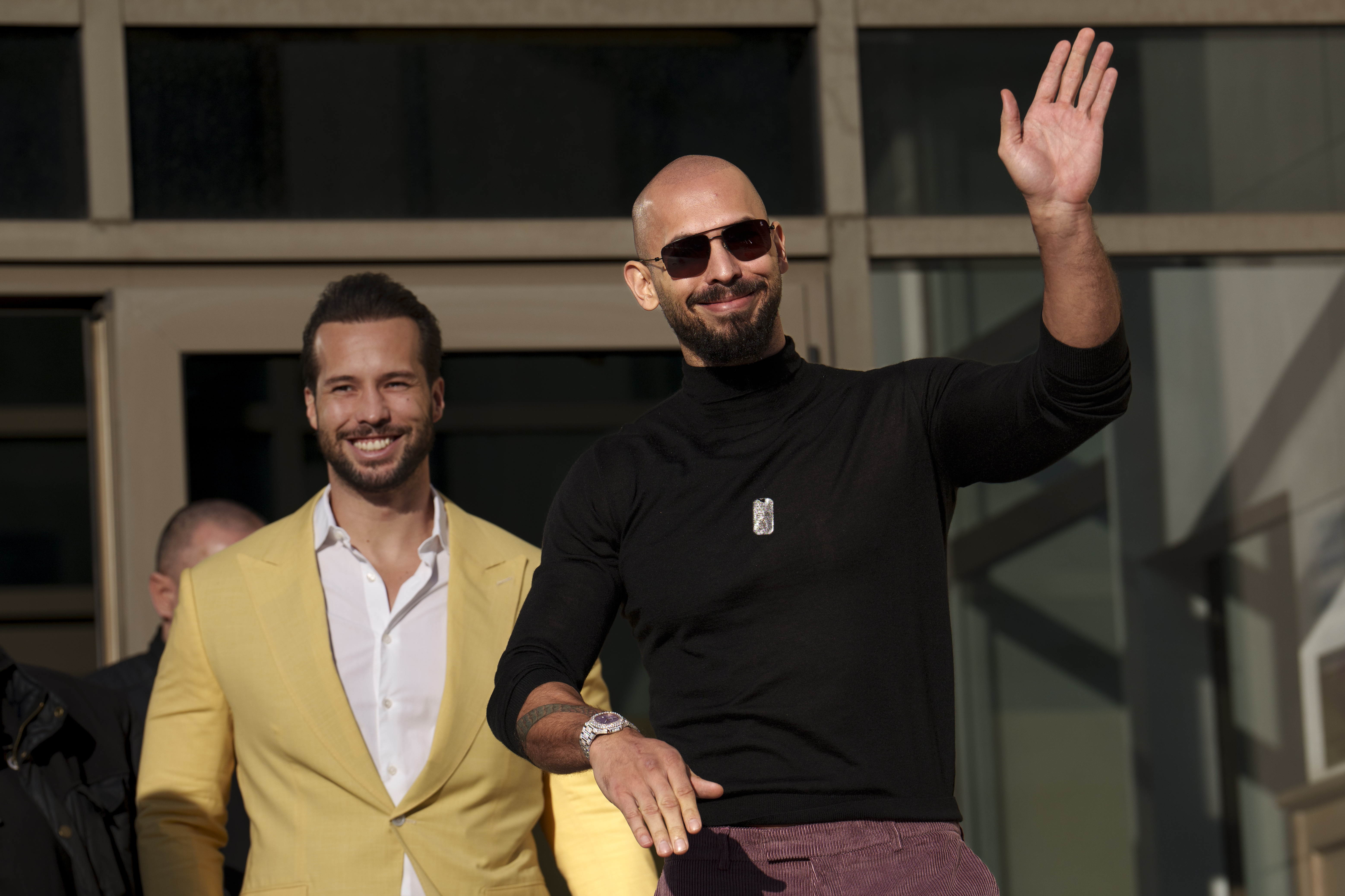 FILE - Andrew Tate waves as he exits the Bucharest Tribunal with his brother Tristan, in Bucharest, Romania, Thursday, Jan. 9, 2025. (AP Photo/Vadim Ghirda, File)