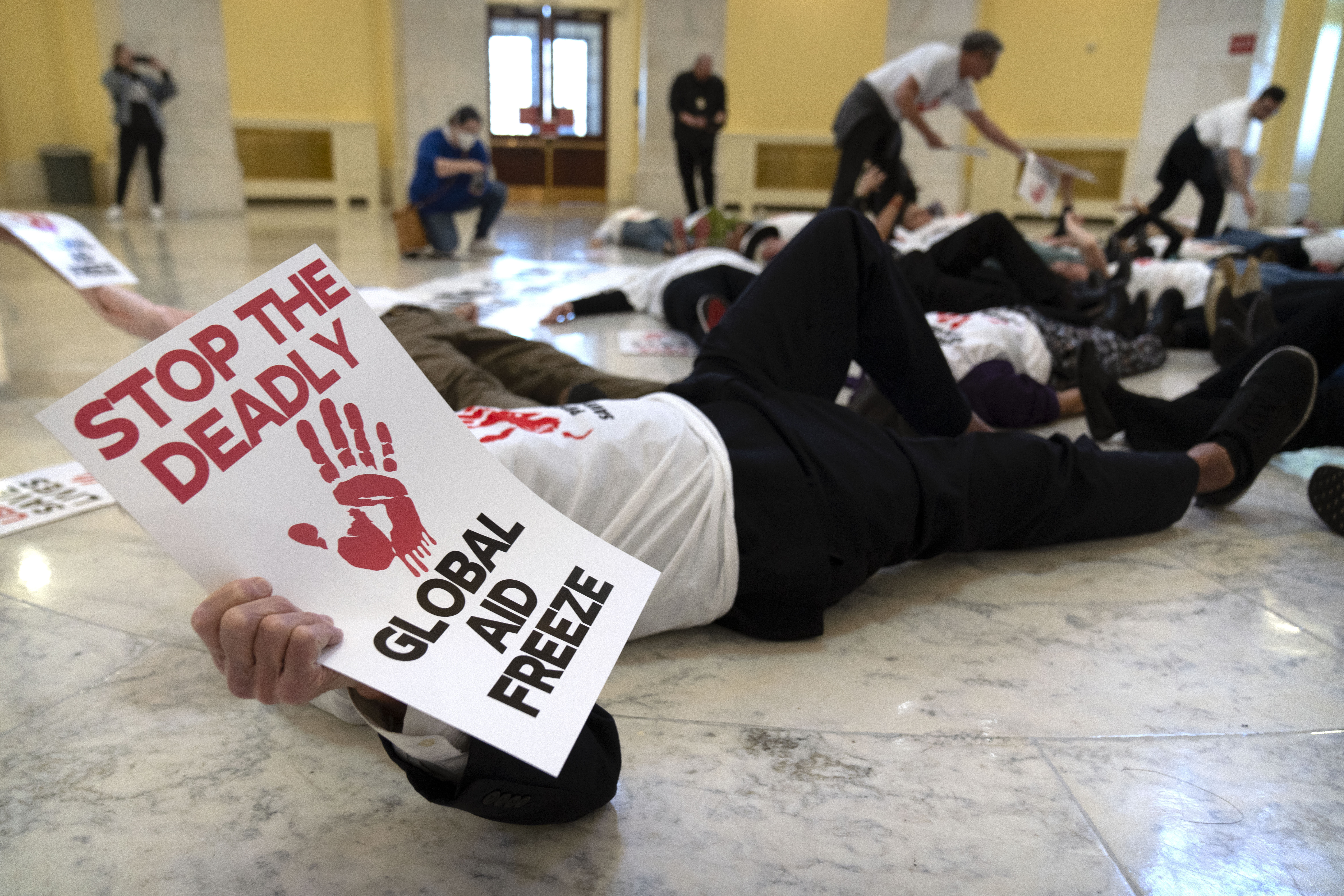 Demonstrators protest against cuts to American foreign aid spending, including USAID and the PEPFAR program to combat HIV/AIDS, at the Cannon House Office Building on Capitol Hill, Wednesday, Feb. 26, 2025, in Washington. (AP Photo/Mark Schiefelbein)