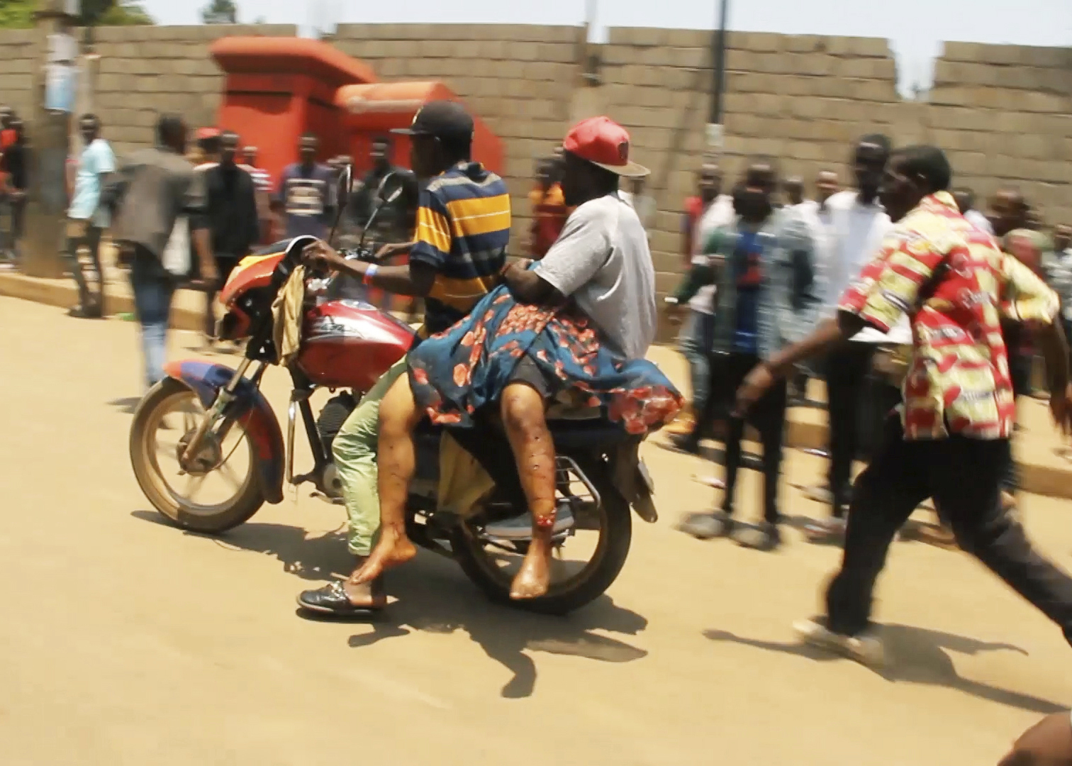 In this video frame grab, people assist victims after two explosions hit a meeting of M23 rebel group leaders and residents in Bukavu, eastern Congo, Thursday, Feb. 27, 2025. (AP Photo/Janvier Barhahiga)