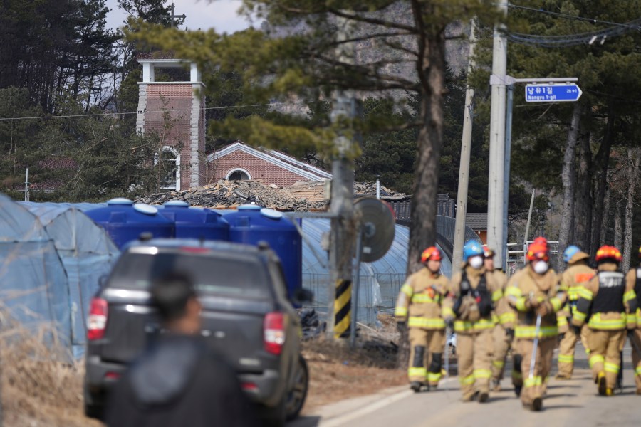 Firefighters walk near the site of an accidental bombing in Pocheon, South Korea, Thursday, March 6, 2025. (AP Photo/Lee Jin-man)