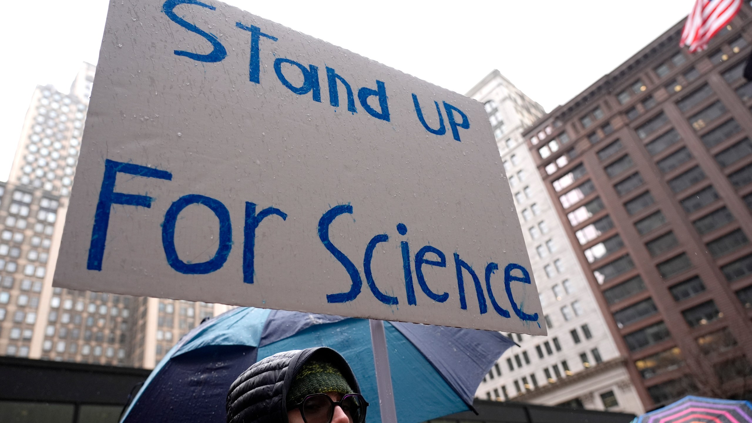 Dylan Pausch holds a sign during a stands up for Science march to protest the Trump administration's science policies and federal job cuts Friday, March 7, 2025, in Chicago. (AP Photo/Nam Y. Huh)