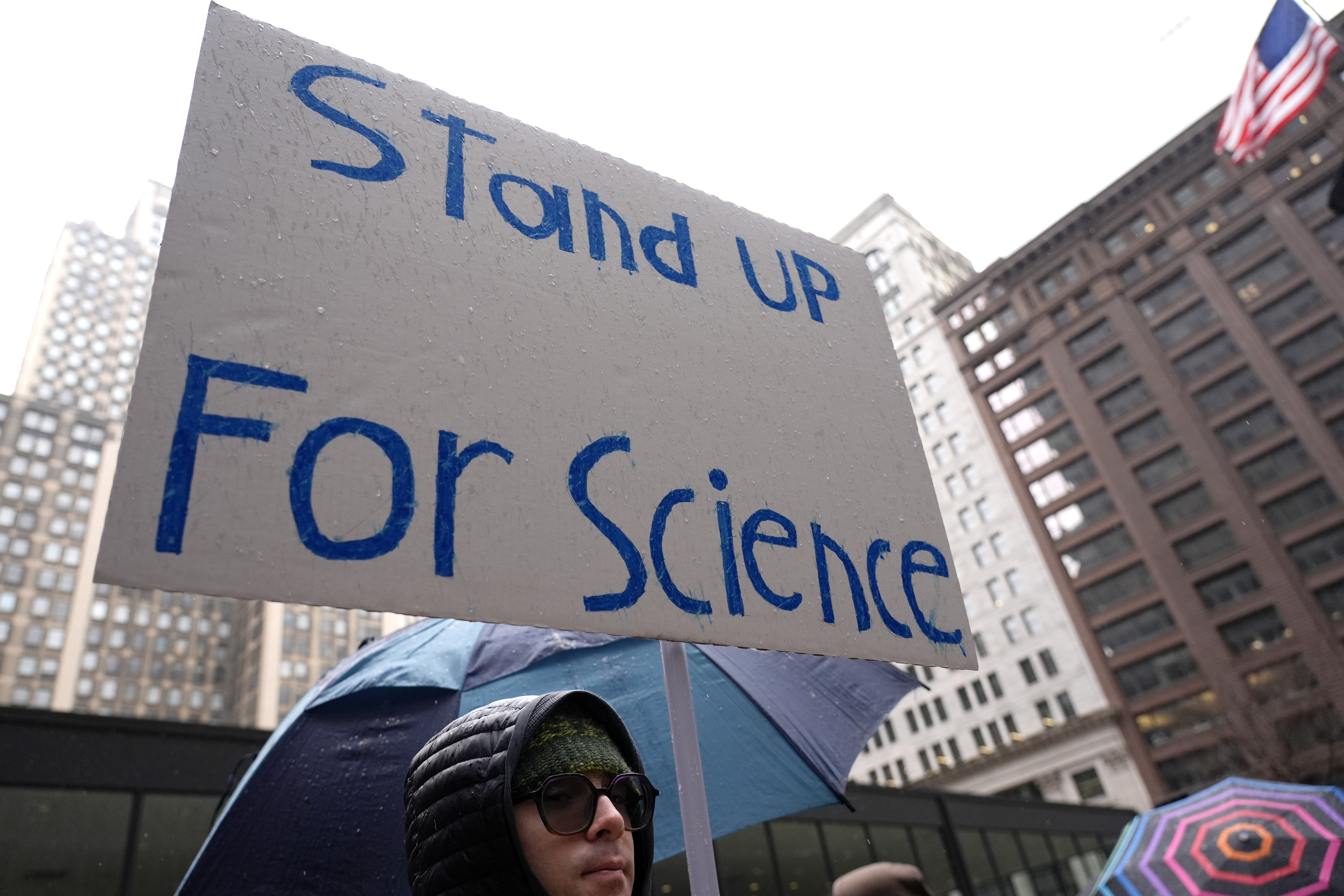 Dylan Pausch holds a sign during a stands up for Science march to protest the Trump administration's science policies and federal job cuts Friday, March 7, 2025, in Chicago. (AP Photo/Nam Y. Huh)