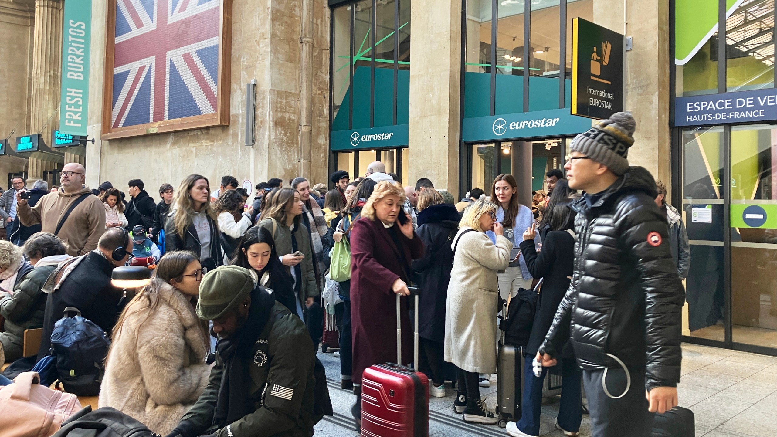 Travelers wait as Eurostar trains to London and all trains heading to northern France have been brought to a halt following the discovery of an unexploded bomb dating back to World War II near the tracks, Friday, March 7, 2025 at the Gare du Nord station in Paris. (AP Photo/Christophe Ena)