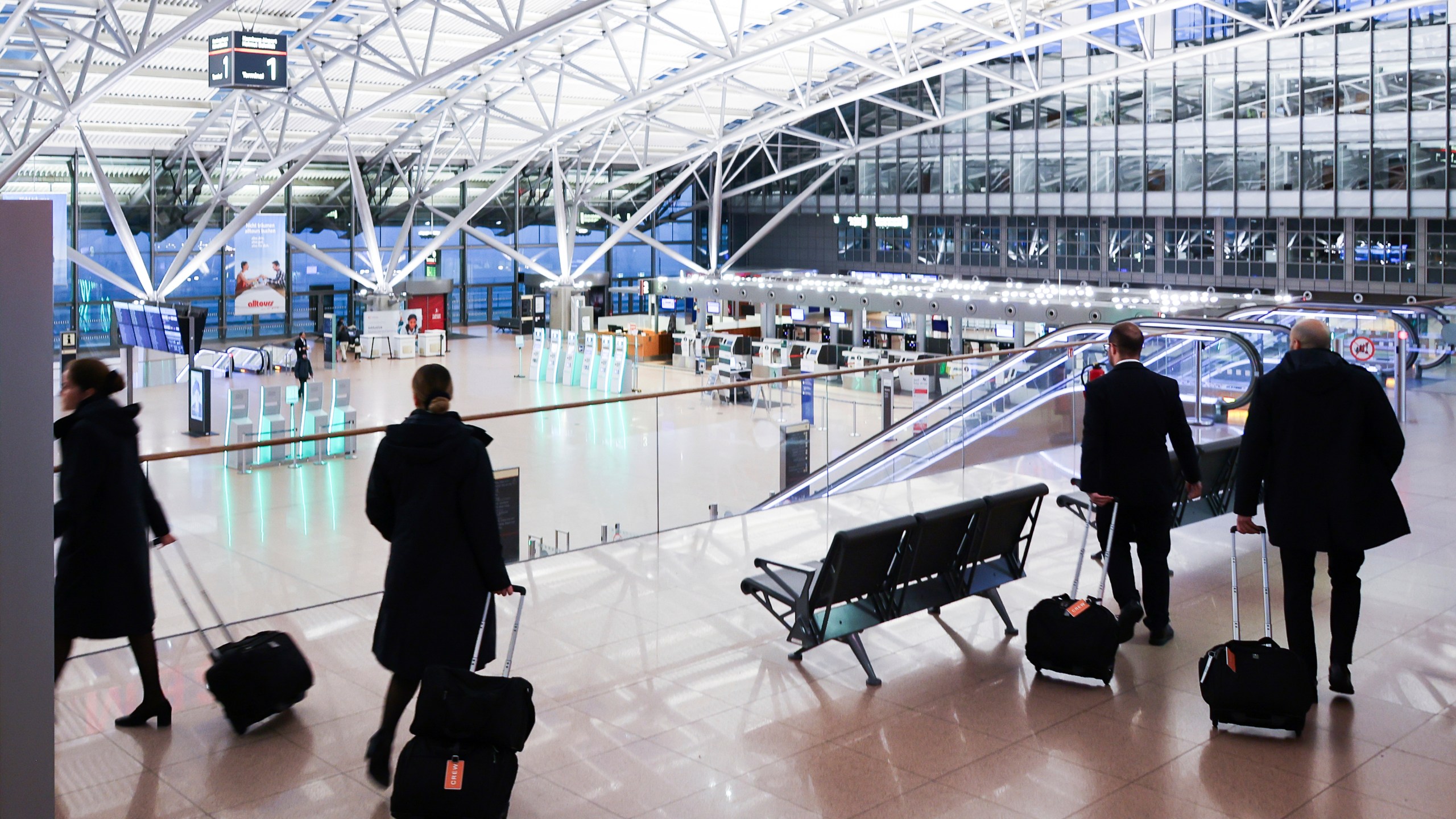 Crew members of an international airline walk through the almost deserted Terminal 1 at Hamburg Airport, Germany Monday, March 10, 2025. (Christian Charisius/dpa via AP)