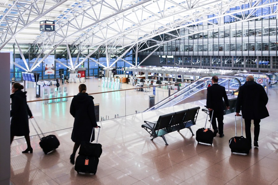 Crew members of an international airline walk through the almost deserted Terminal 1 at Hamburg Airport, Germany Monday, March 10, 2025. (Christian Charisius/dpa via AP)