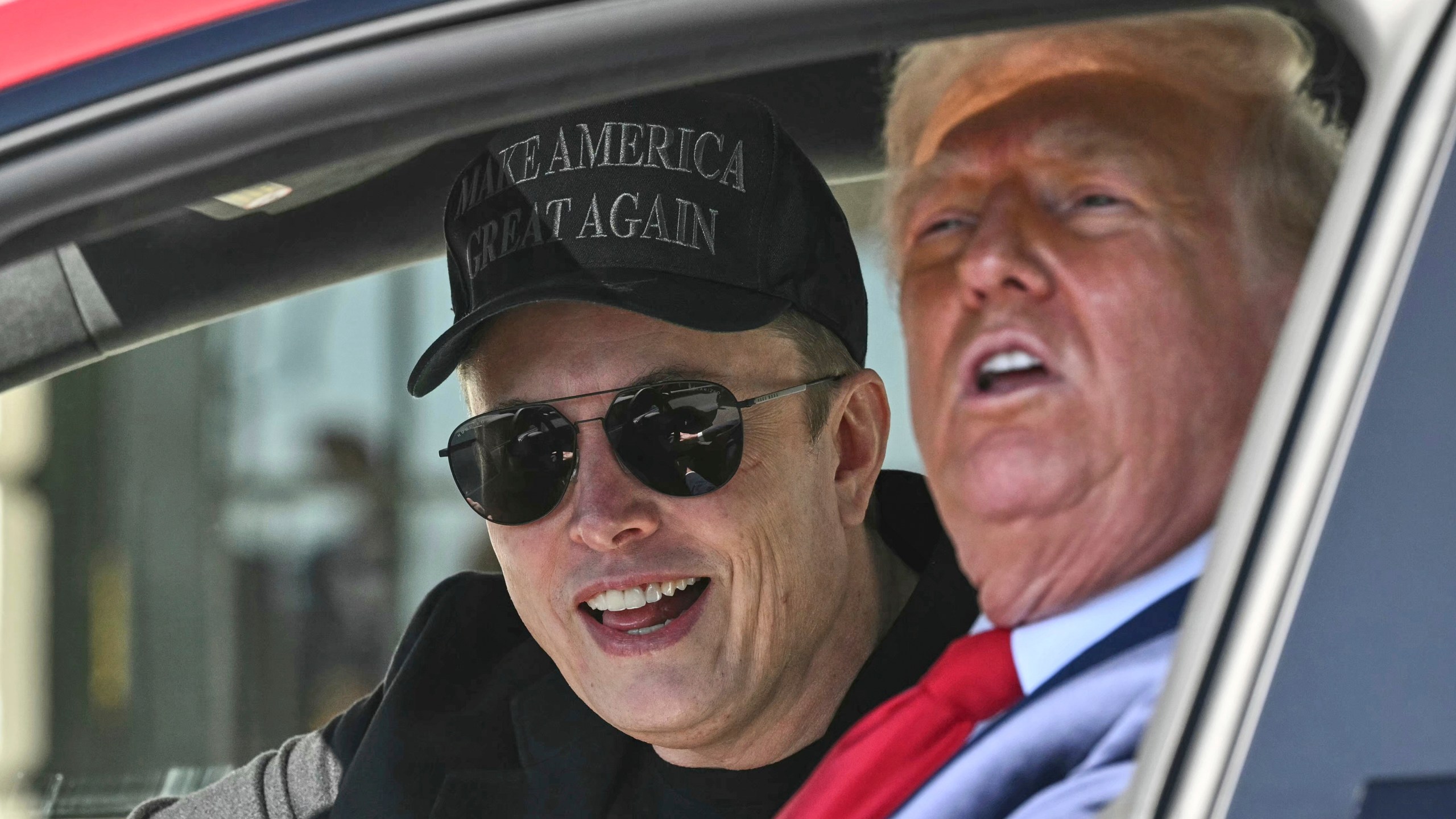 President Donald Trump and Tesla CEO Elon Musk speak to reporters as they sit in a Tesla vehicle on the South Lawn of the White House Tuesday, March 11, 2025, in Washington. (Pool via AP)