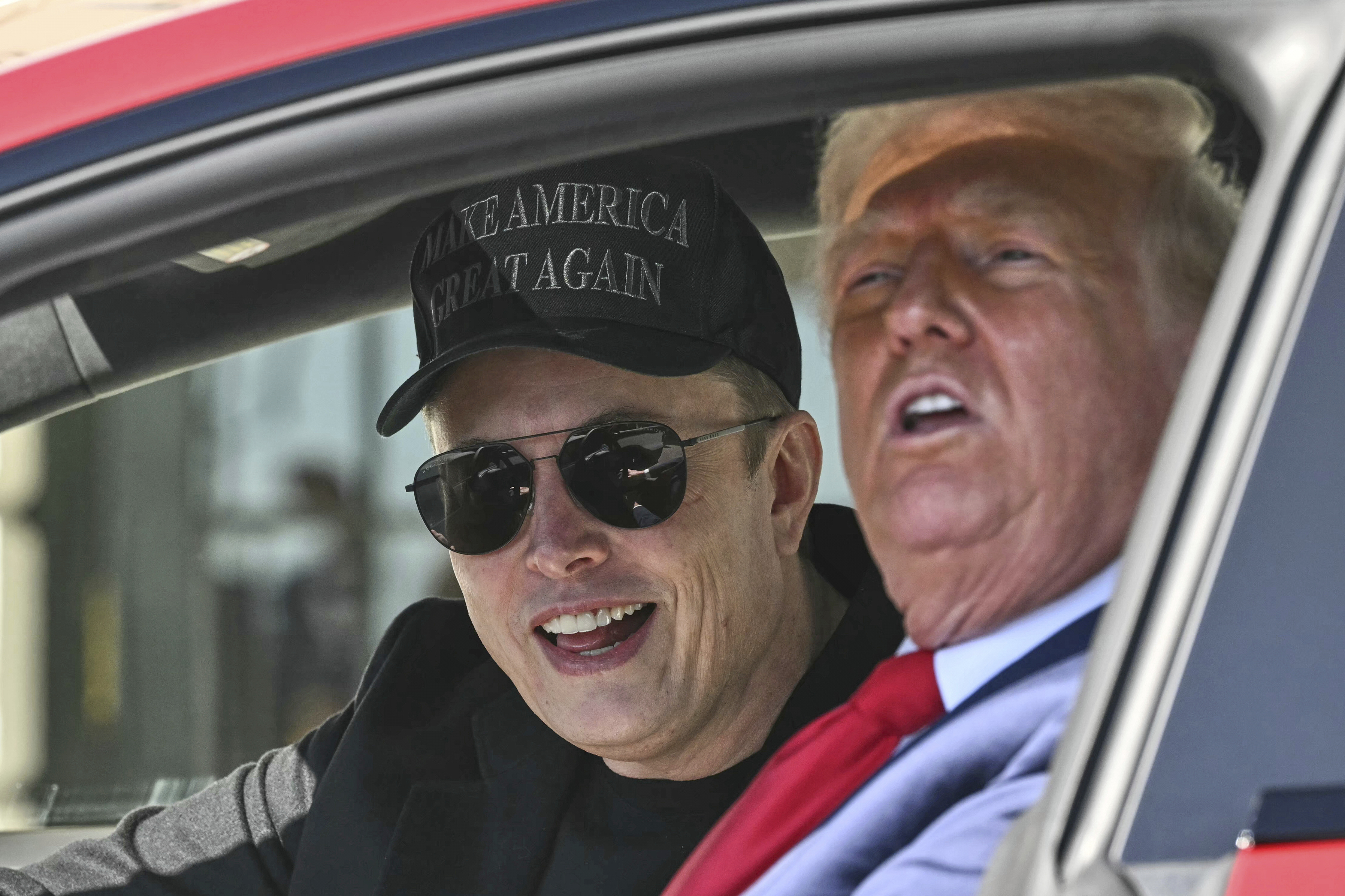 President Donald Trump and Tesla CEO Elon Musk speak to reporters as they sit in a Tesla vehicle on the South Lawn of the White House Tuesday, March 11, 2025, in Washington. (Pool via AP)